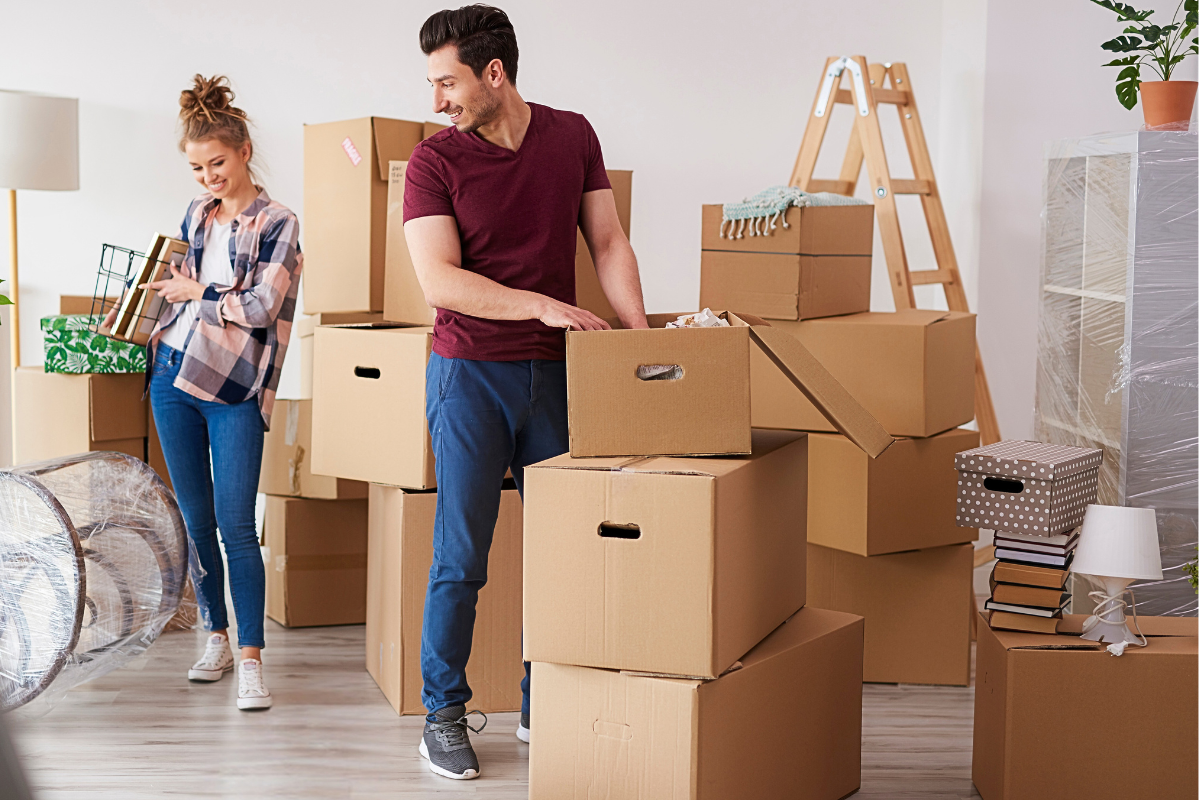Couple surrounded by moving boxes unpacking and organizing their new home.