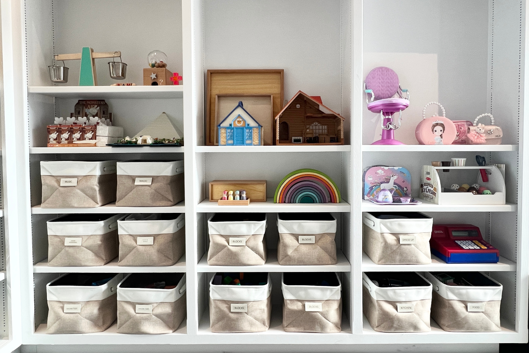 Custom organized children’s playroom shelving in Palos Verdes Estates, California, featuring calm, neutral fabric storage bins labeled by category, curated toys displayed on open shelves, and intuitive systems designed to support independence, easy d
