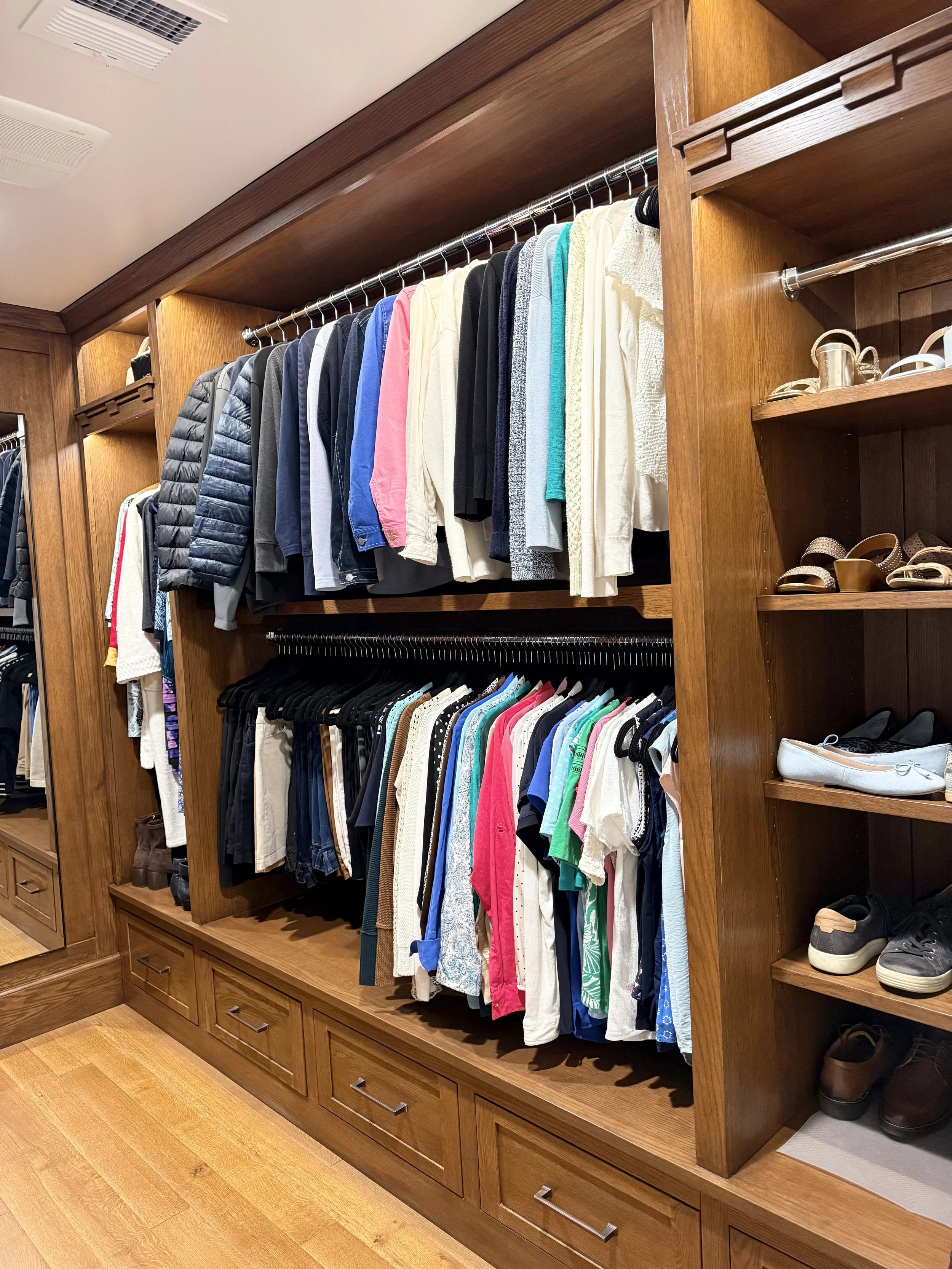 Feature primary closet organization in North Tustin, Cowan Heights, California, showcasing custom double-hanging zones, integrated shoe shelving, and built-in drawer storage. Clothing is thoughtfully edited and arranged by category and length to crea