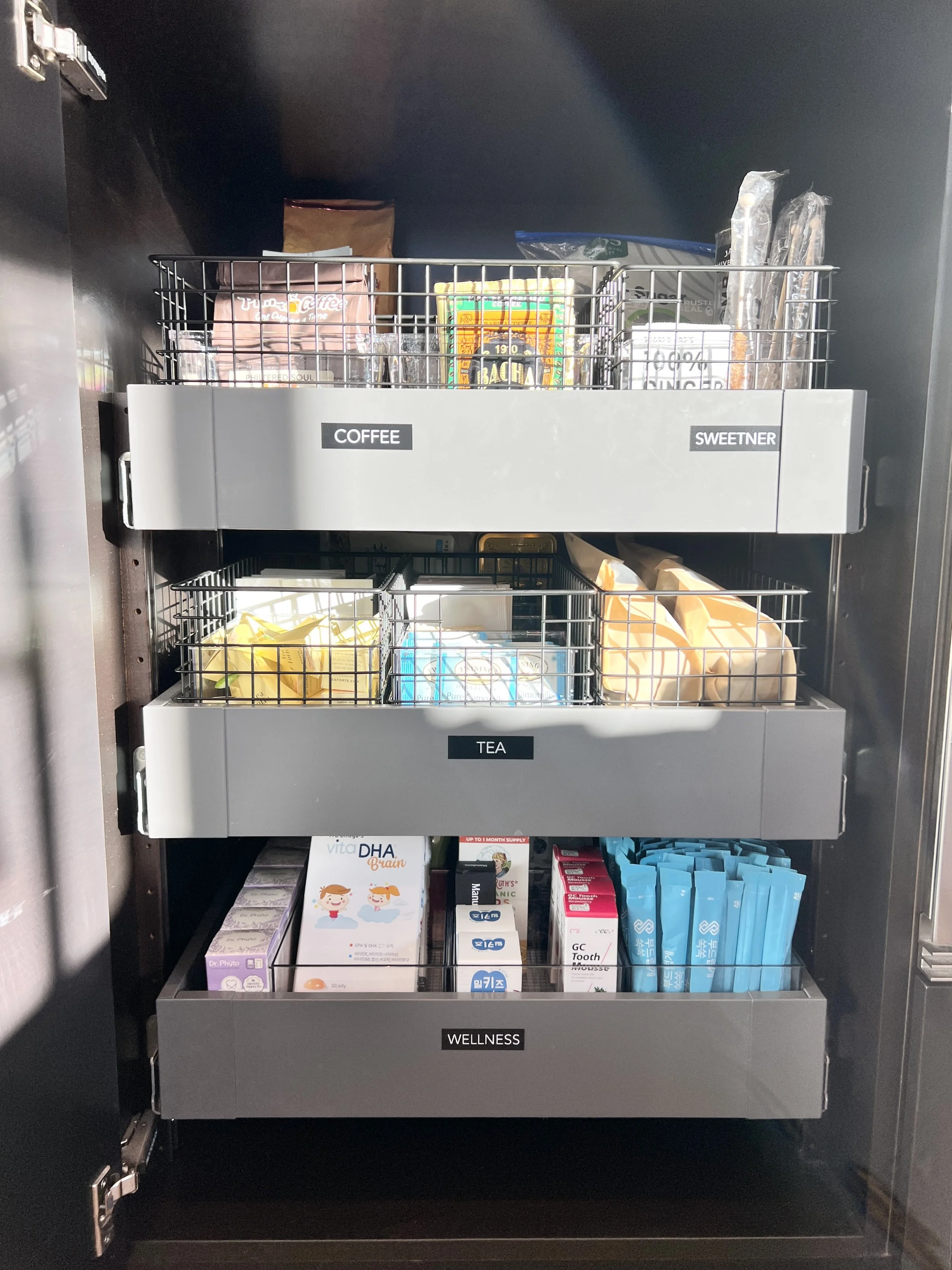 Custom pantry cabinet organization in Palos Verdes Estates, California, featuring labeled pull-out drawers for coffee, tea, sweeteners, and wellness essentials. Thoughtfully edited categories and streamlined storage systems create clear visibility, e