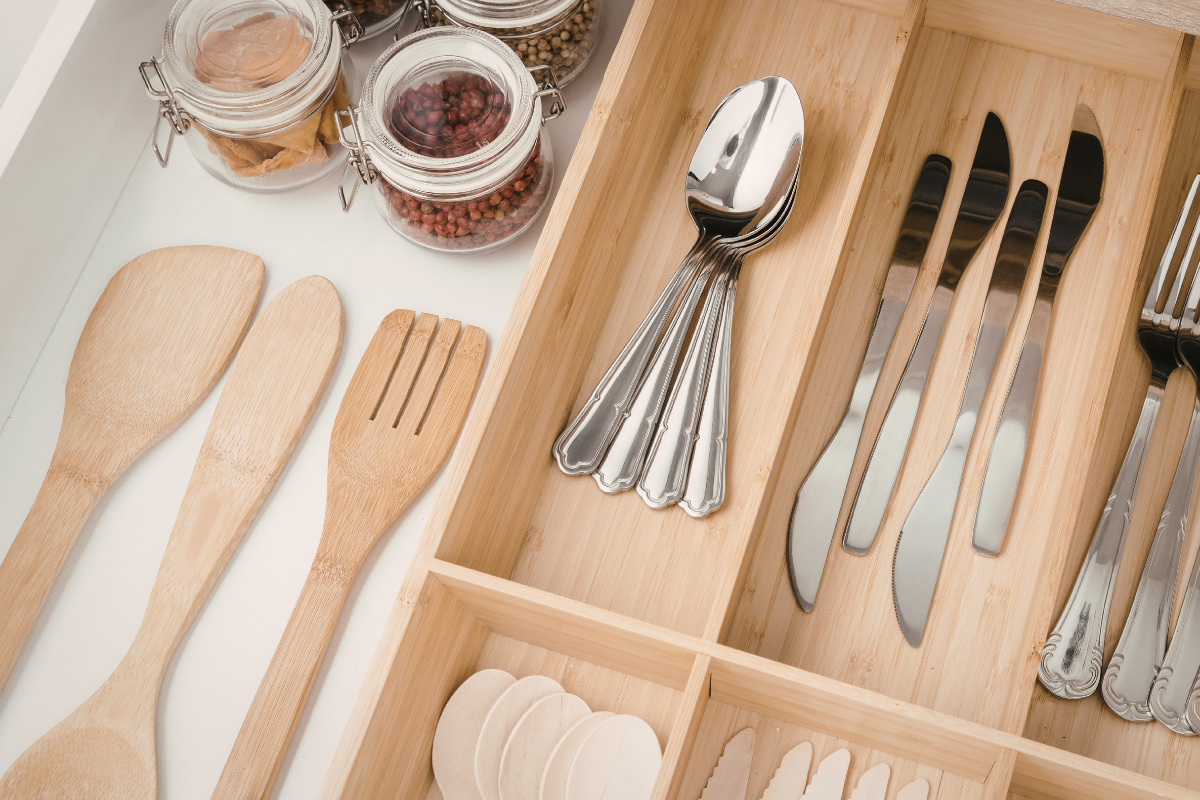 Organized kitchen drawer with neatly arranged utensils in a minimalist system designed for everyday ease