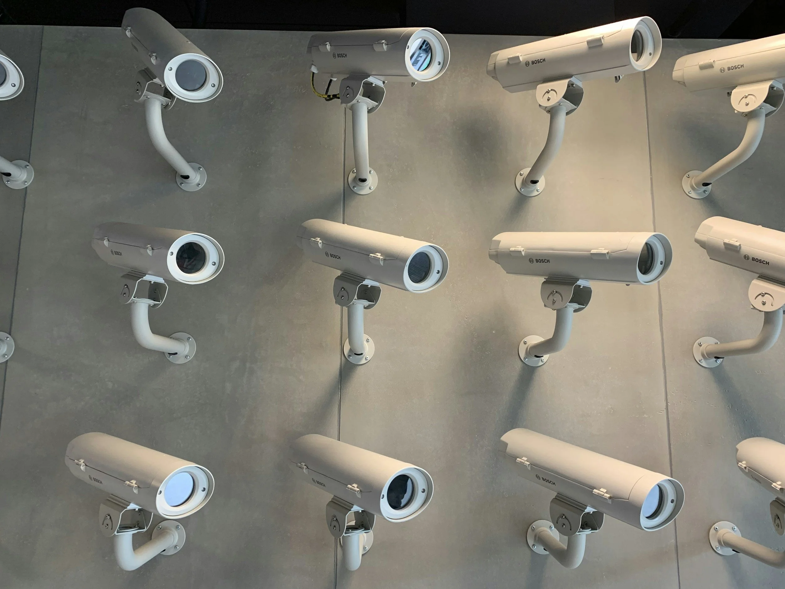 Multiple white security cameras mounted on a ceiling in a grid pattern. Staunton Security, Stauntonsecurity.com
