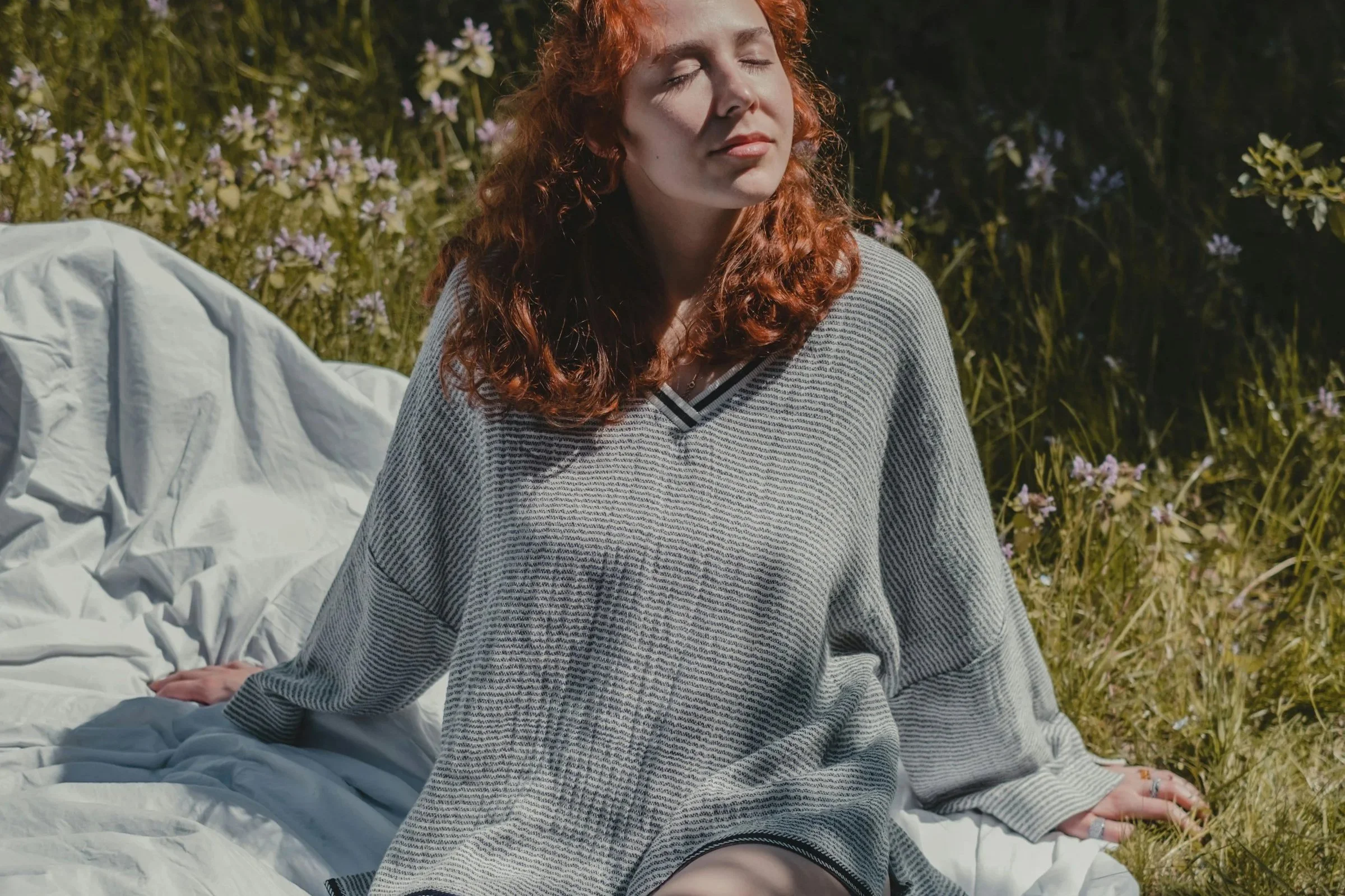 Woman sitting down relaxing on a green field
