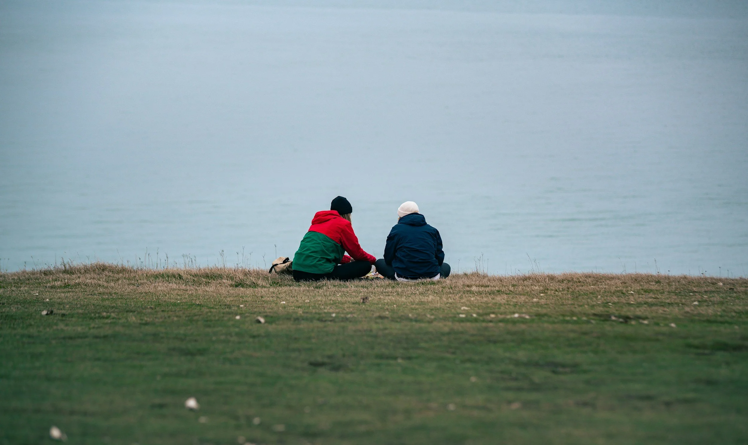 two people talking with the water in the distance