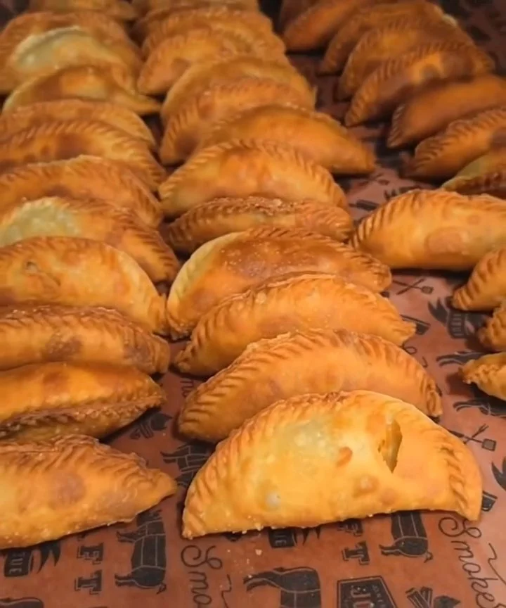 A pile of crispy, golden-brown fried empanadas