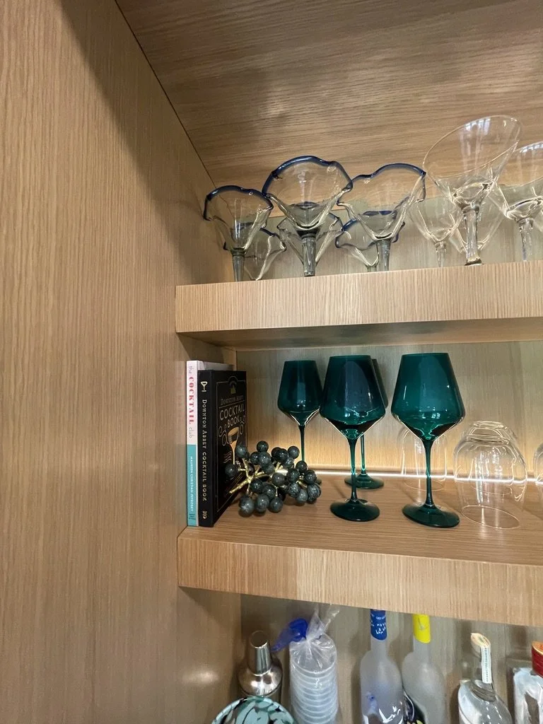 Wooden shelf with assorted glassware and books