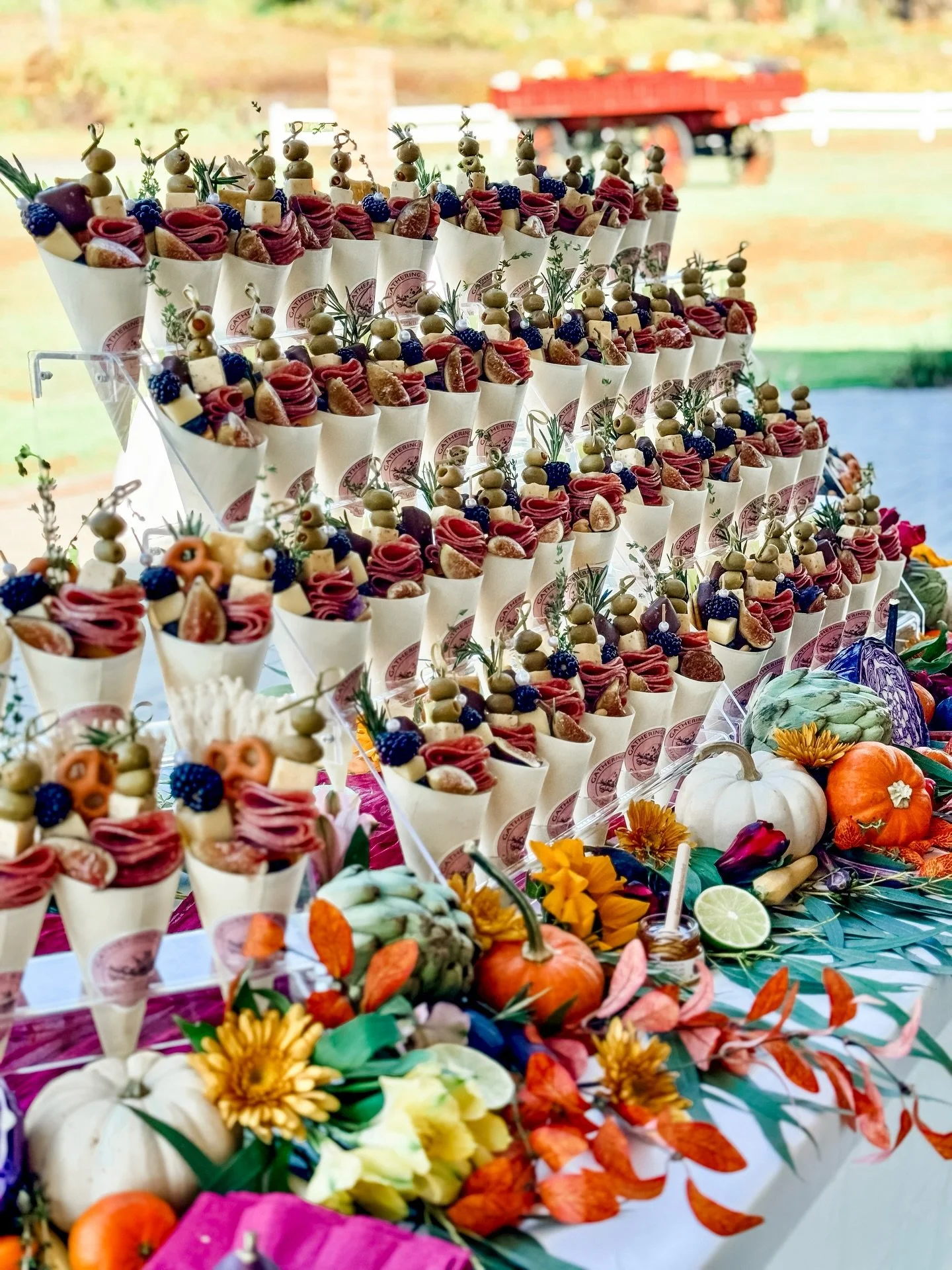 A little peek at one of our favorite fall cone tables 🍇🌿 Every cone is packed with meats, cheeses, olives, and fruit &mdash; and then dressed up with seasonal florals and pumpkins. Almost too pretty to eat&hellip; almost.