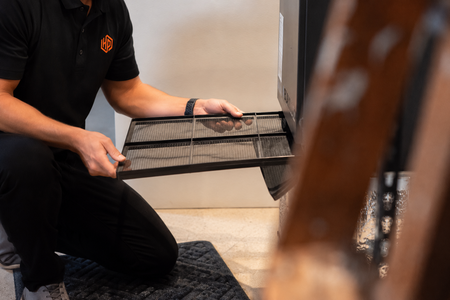 Only Heat Pumps technician removing and inspecting a heat pump air filter during routine maintenance in Maine.