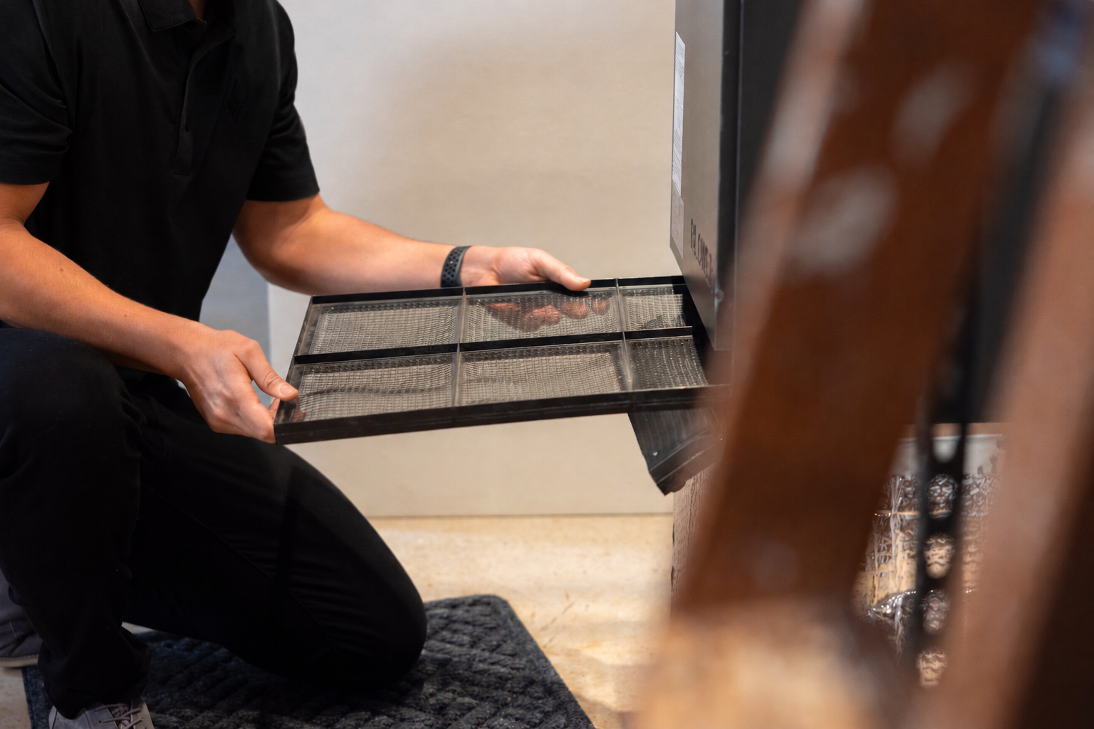 Technician checking a heat pump filter during fall maintenance at a home in Maine.