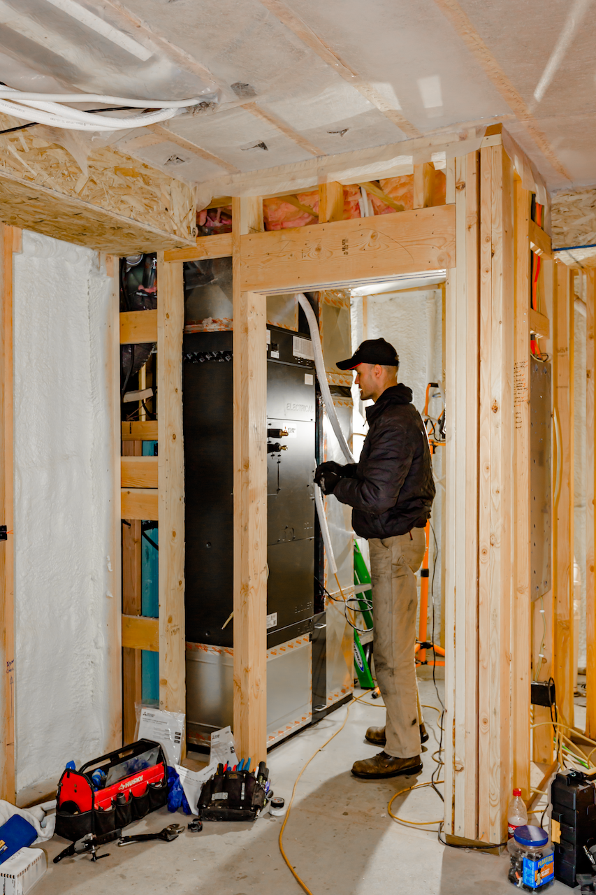 Technician installing a ducted heat pump system in a Southern Maine home.