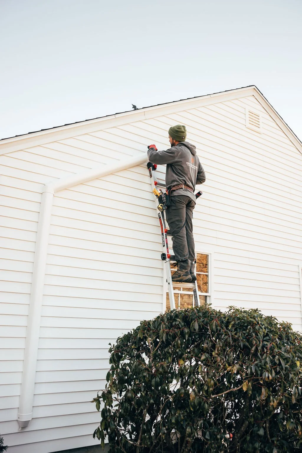 An Only Heat Pumps technician installing a heat pump line set on a Southern Maine home during a professional heat pump installation.