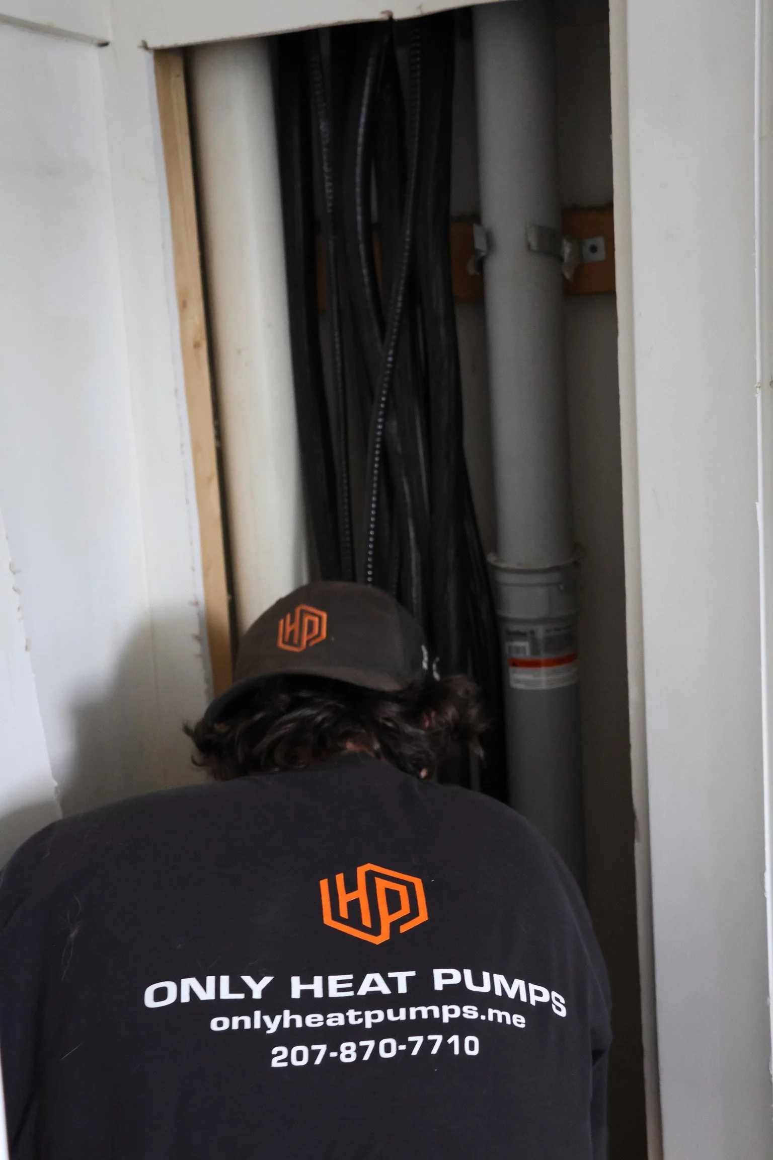 HVAC technician servicing an indoor heat pump to prepare a home for winter heating.