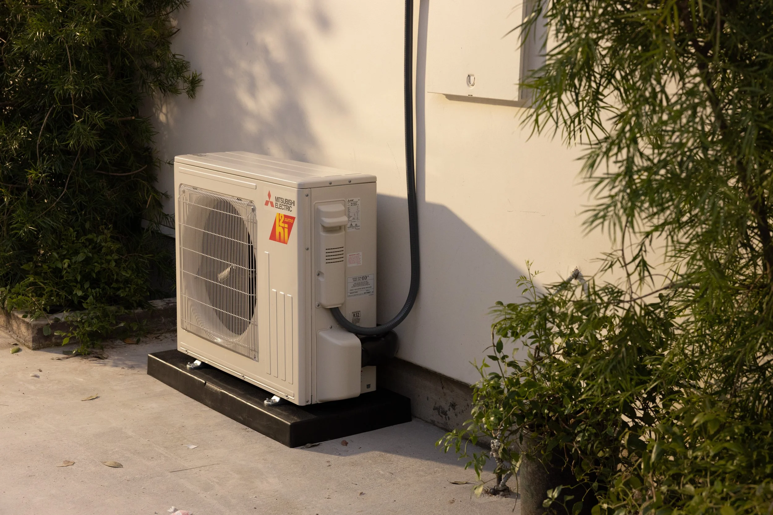 Mitsubishi ductless heat pump outdoor unit at a Southern Maine home, representing professional heat pump cleaning and maintenance services.