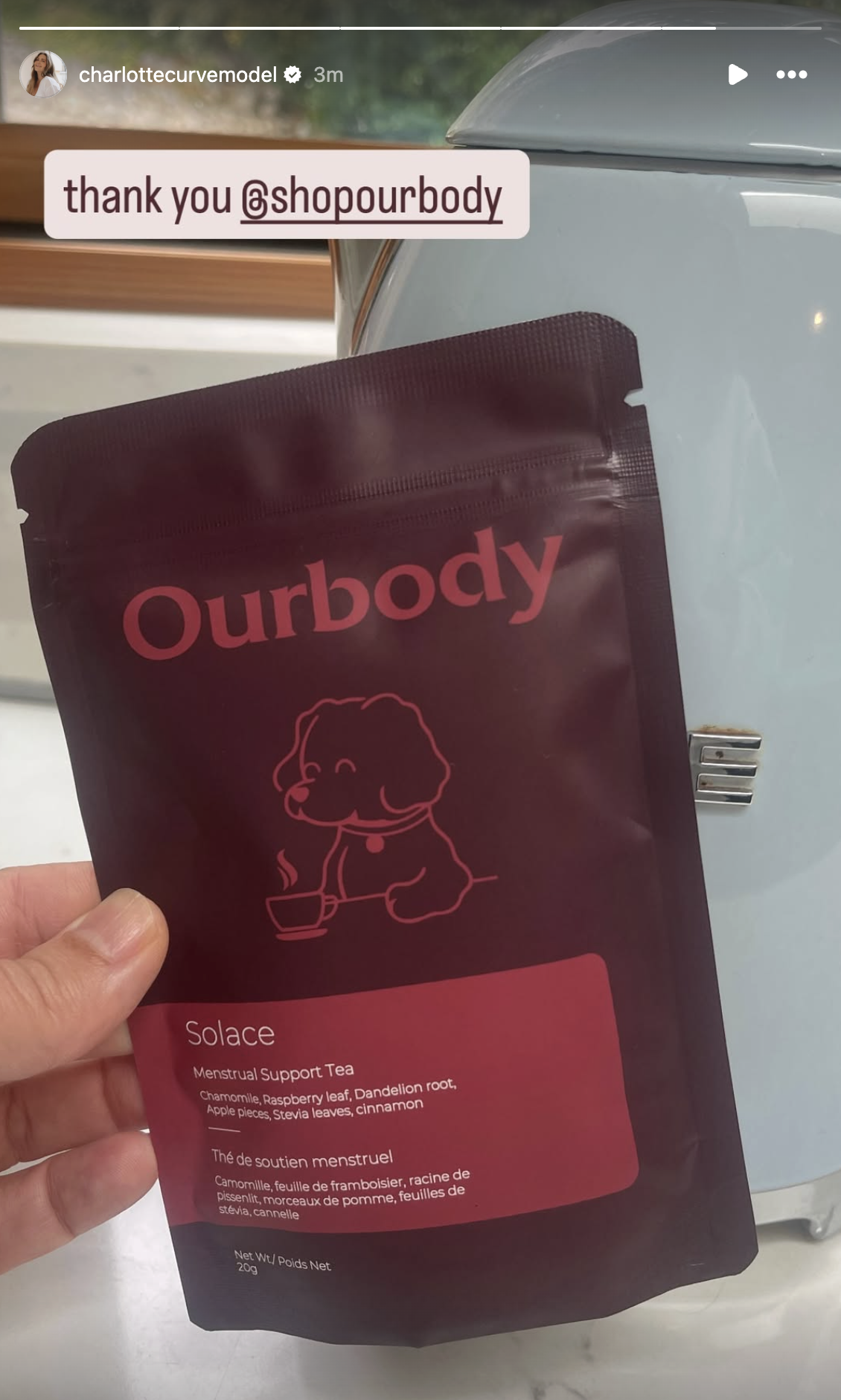 A person holding a package of Ourbody Solace Menstrual Support Tea in front of a white appliance, with a thank you message to @shopourbody