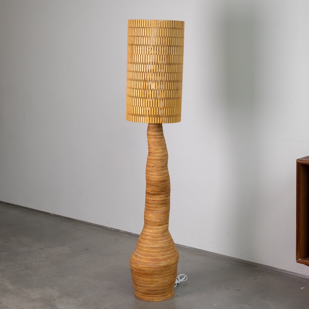 This handcrafted floor lamp is a bold expression of organic form and engineered precision. Made entirely from stacked and sculpted plywood rings, it casts mesmerizing patterns of light and shadow that transform any space into a warm, modern retreat.