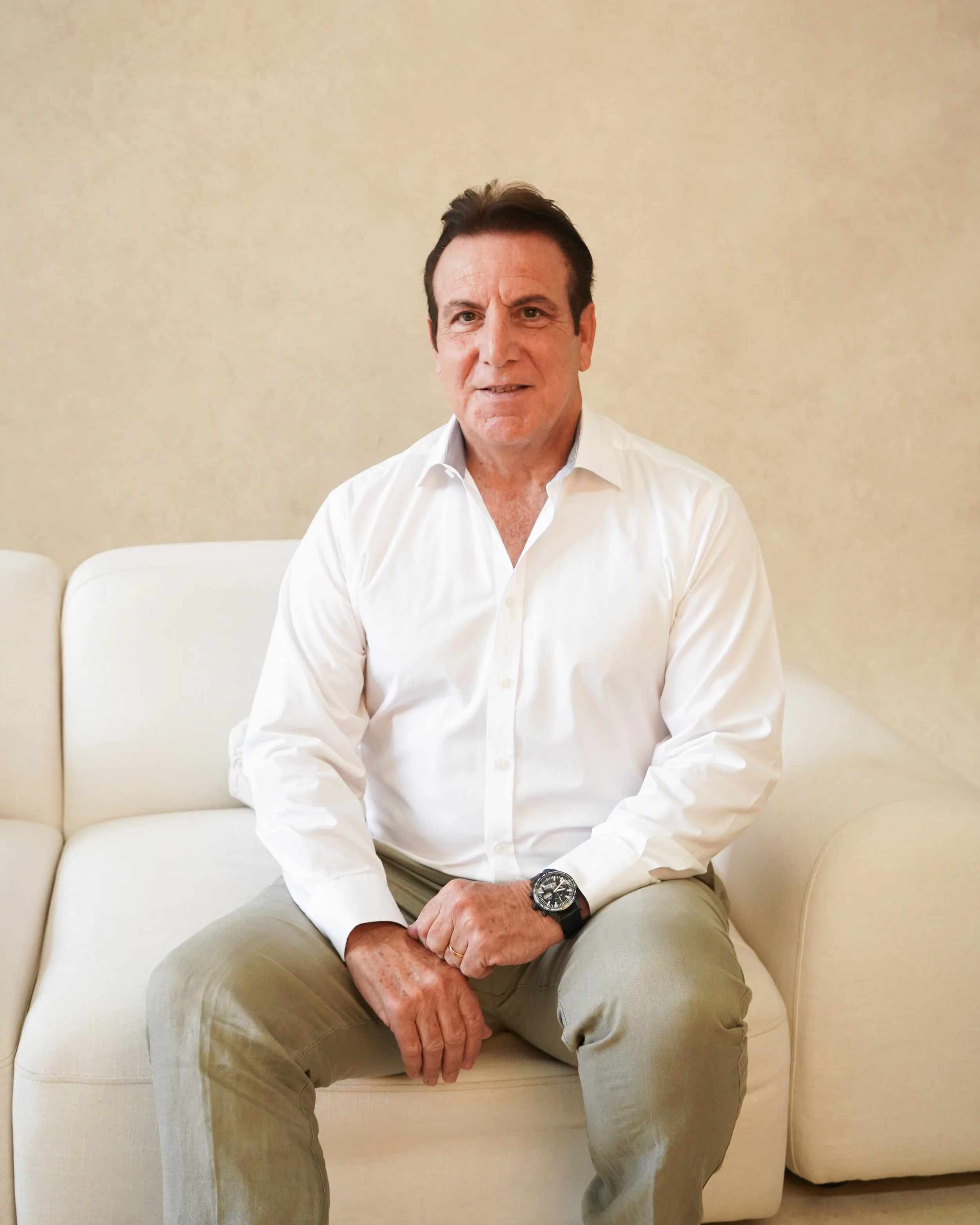 Black and white photo of a man in a suit seated against a plain background.