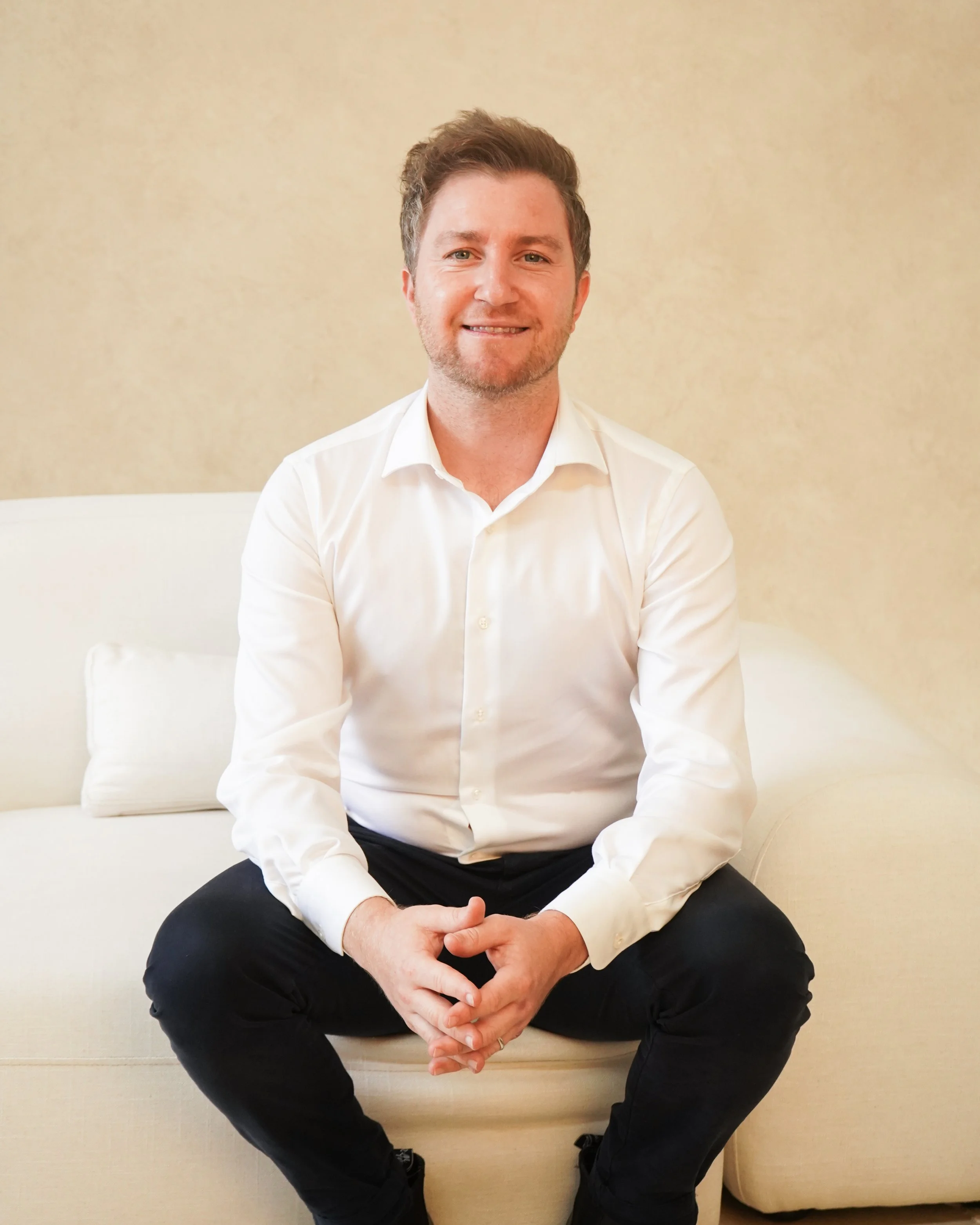 Man in a suit sitting on a stool, black and white photo