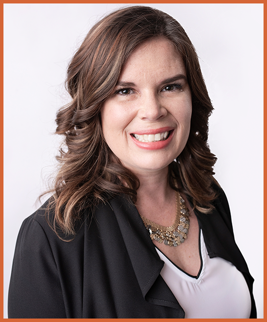 A woman with shoulder-length brown hair smiling, wearing a black blazer and a statement necklace, in front of a white background with an orange border.