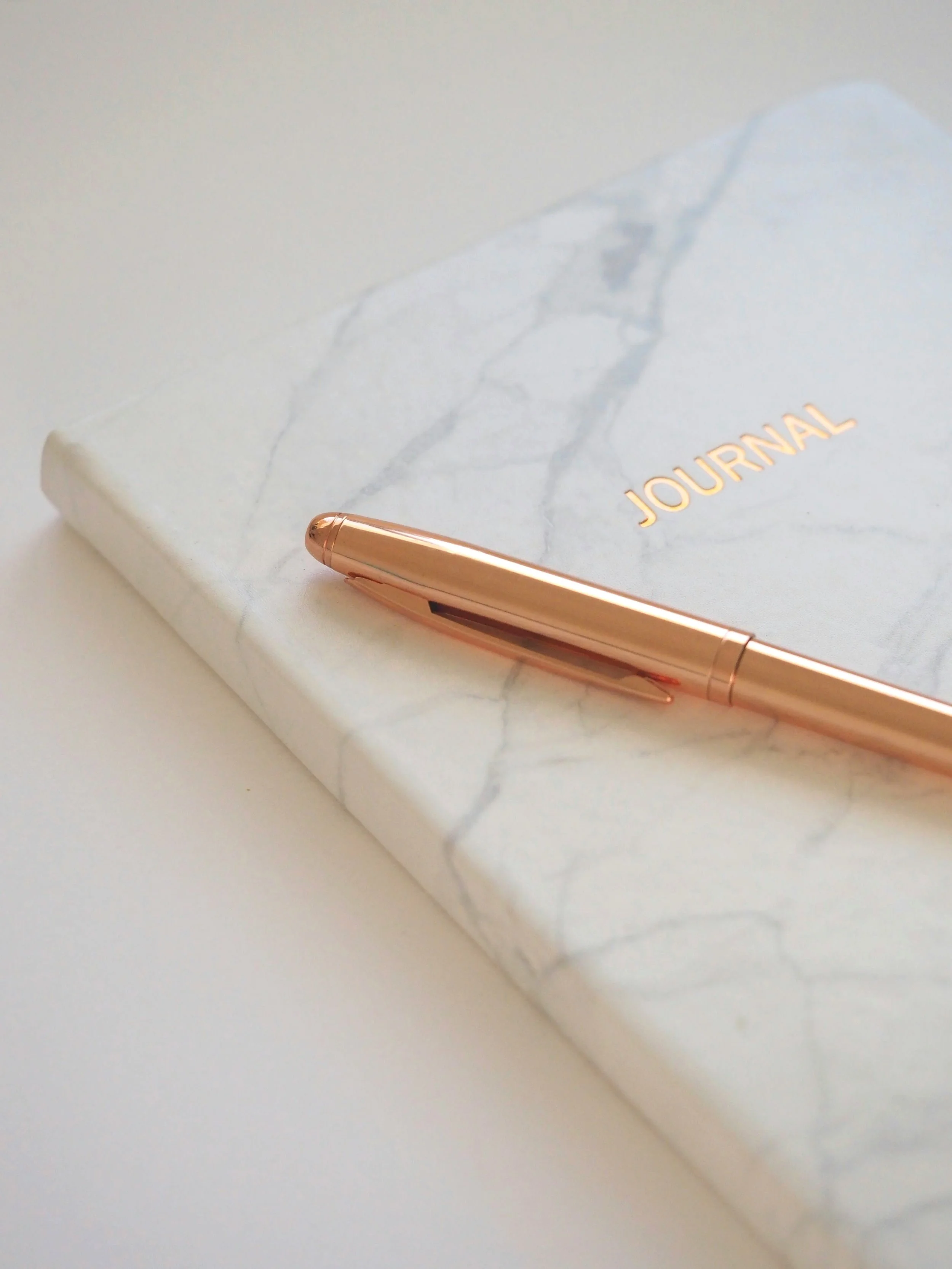 Marble journal with a gold pen, symbolizing self-reflection and personal growth in therapy