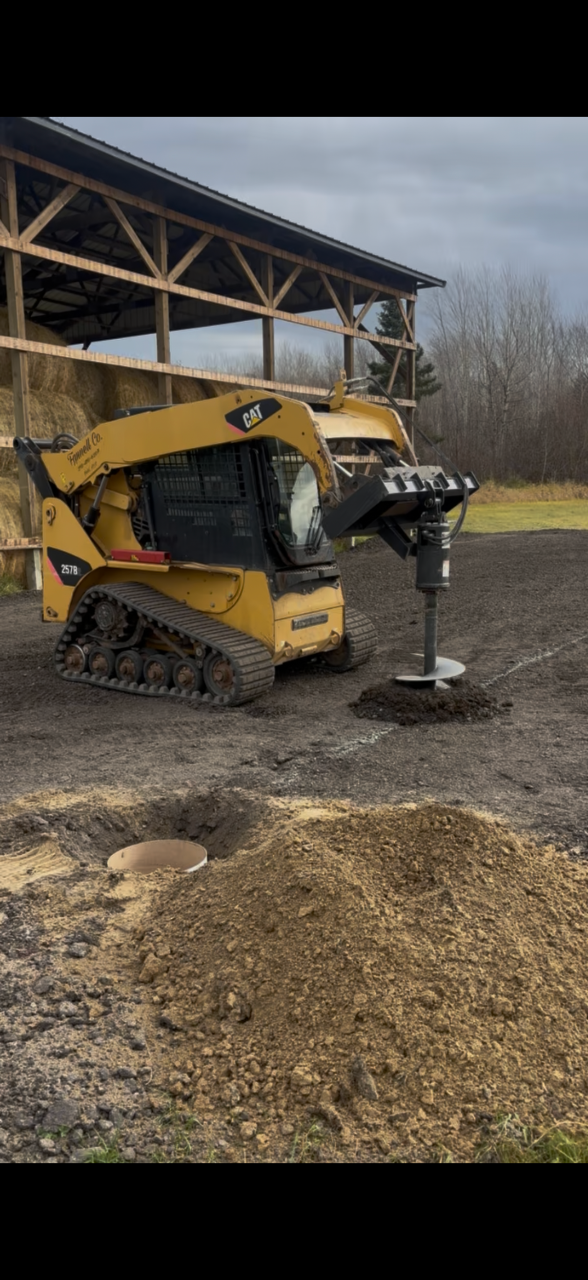 Augering holes for a post frame building we built.