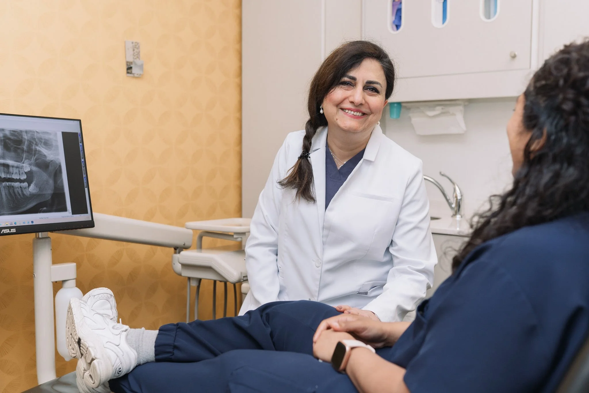Dr. Firouzeh Malekian speaking with a patient during their cosmetic consultation at Aarm Dental Group on Denman. We listen, support, & help you make confident choices about your oral health.