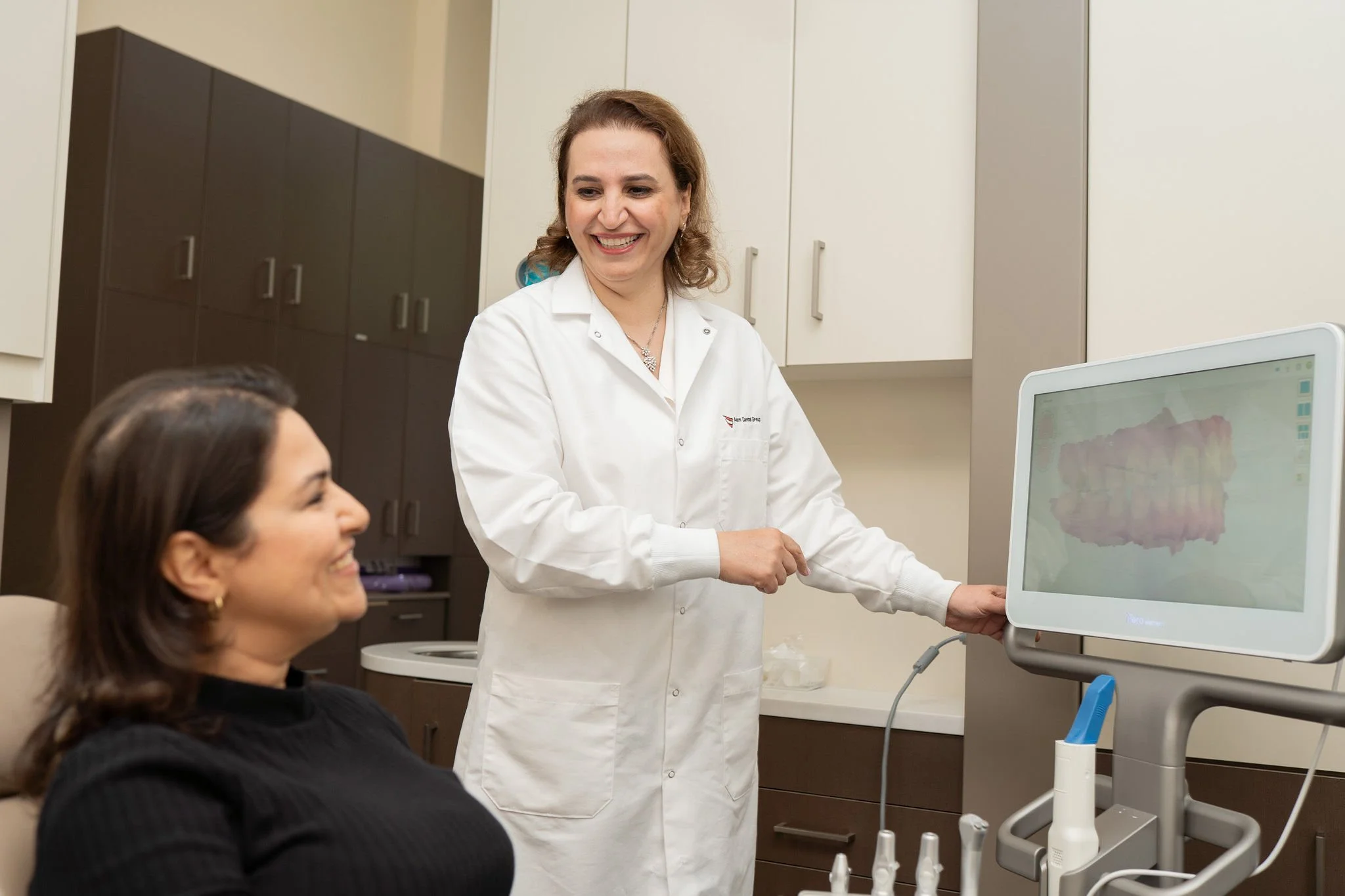 Dr. Roya Naseh speaking with a patient during their cosmetic consultation at Aarm Dental Group on Beatty. We listen, support, & help you make confident choices about your oral health.
