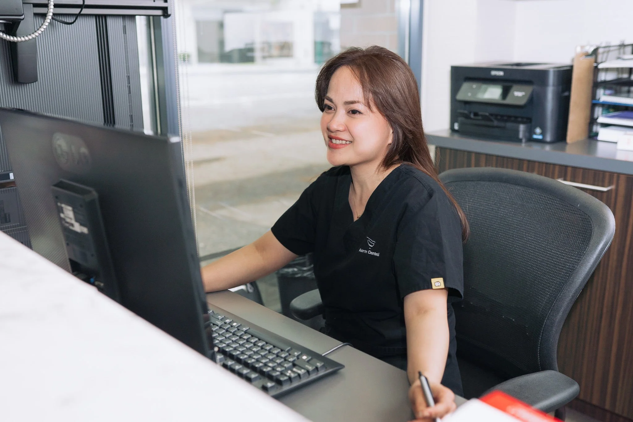 Friendly receptionist at Aarm Dental Group at BC Place greeting patients. We accept most insurance plans and the new CDCP to make your visit smooth and affordable.