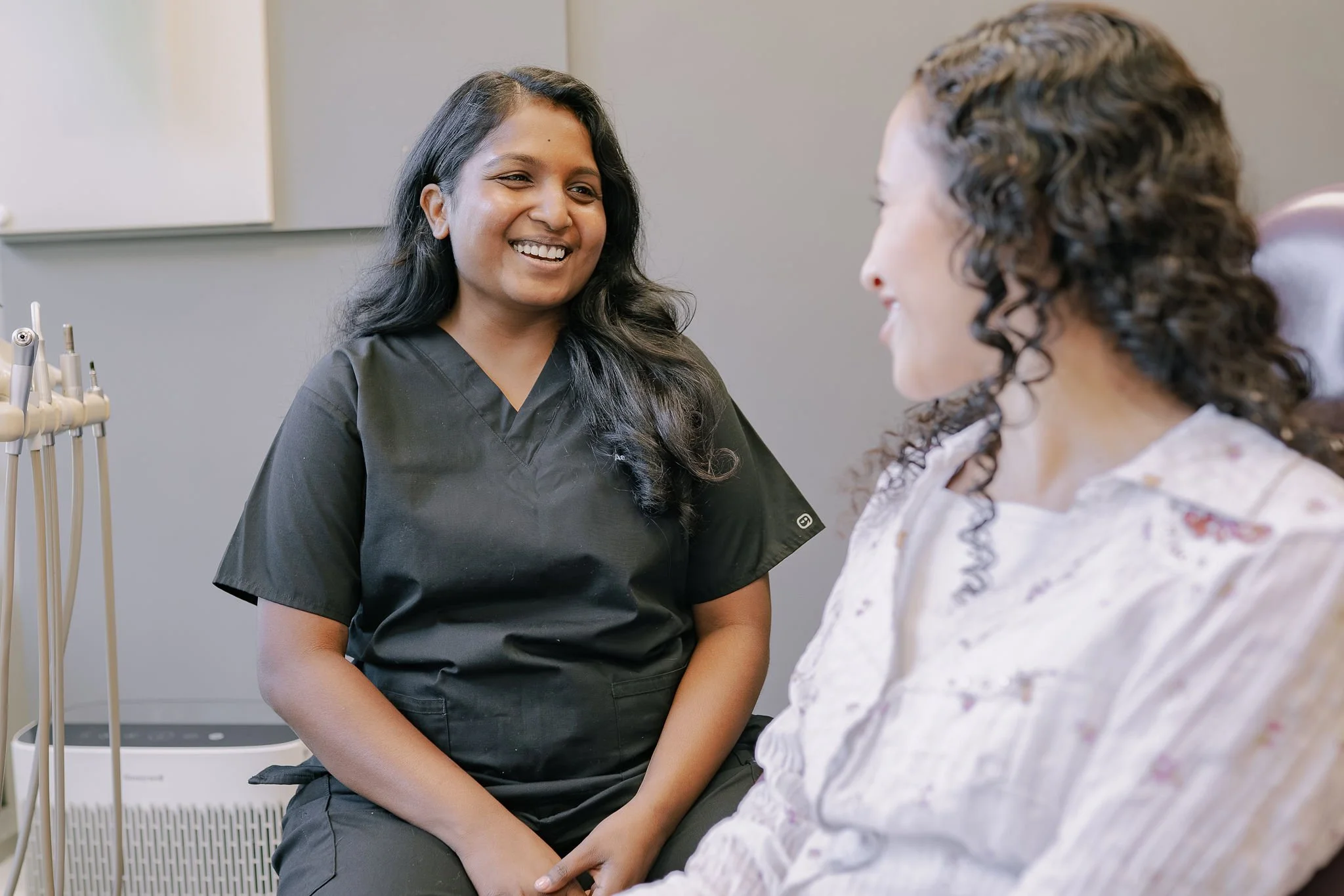 Dr. Pearly Dason speaking with a patient during their cosmetic consultation at Aarm Dental Group on Beach. We listen, support, & help you make confident choices about your oral health.