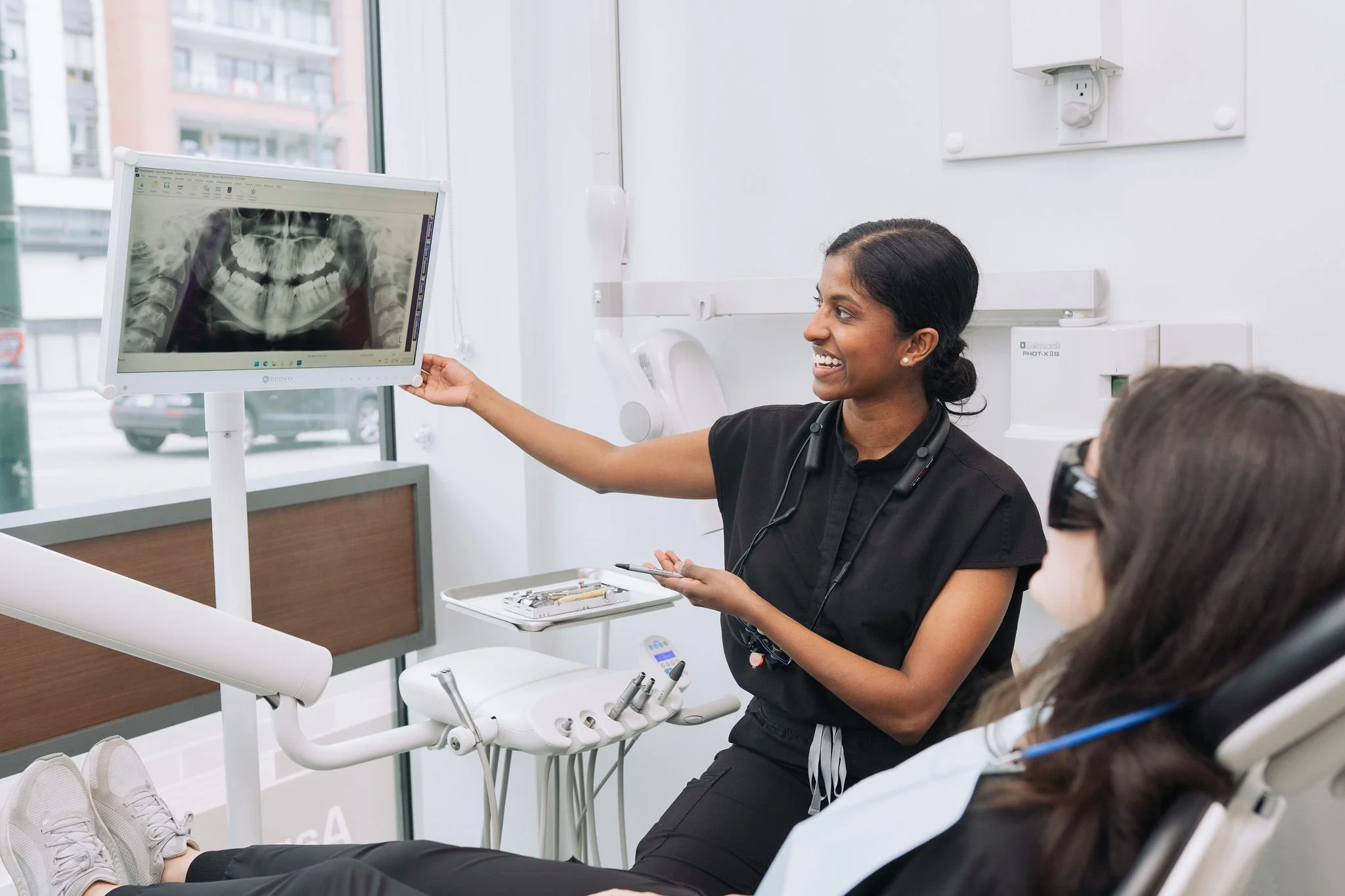 A dentist showing a dental X-ray to a patient in a dental office.