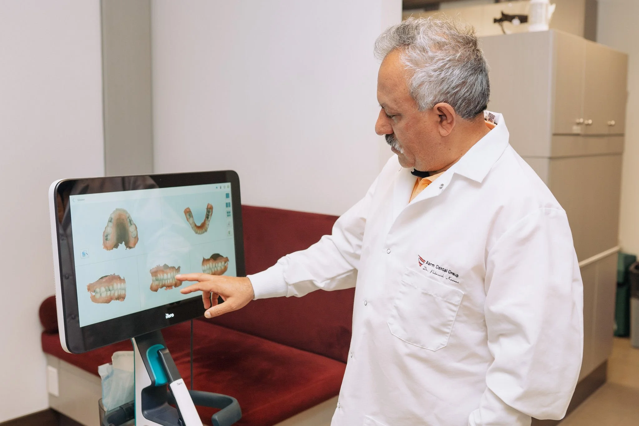 Picture of a dentist looking at 3d image of a mouth