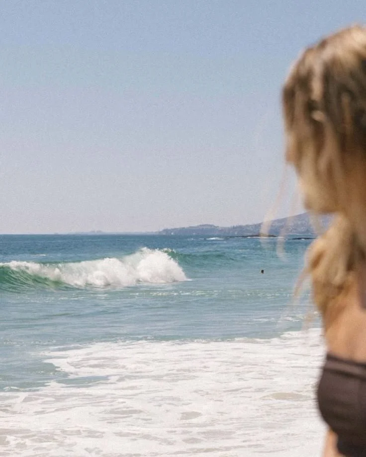 Beach scene with ocean waves and blurred person in foreground