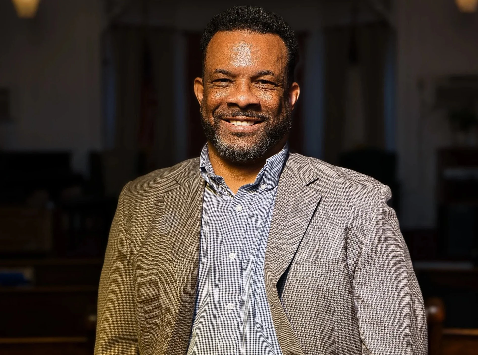 Professional portrait of a businessman smiling with hands in pocket no tie