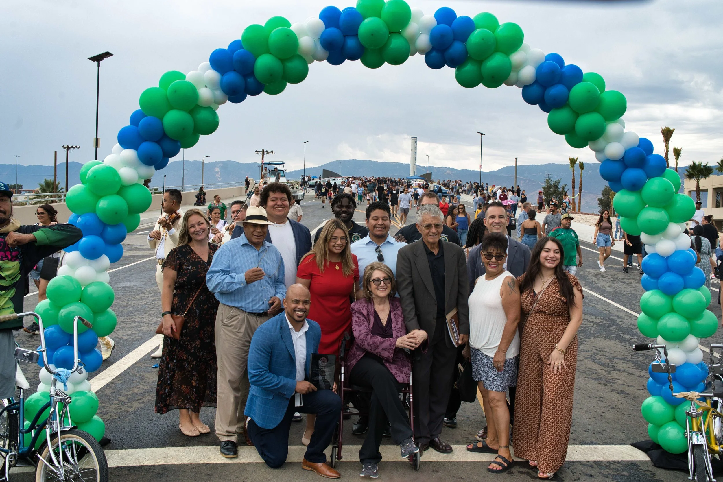 Image of predomin city members in front of a balloon arch right after a ribbon cutting outside