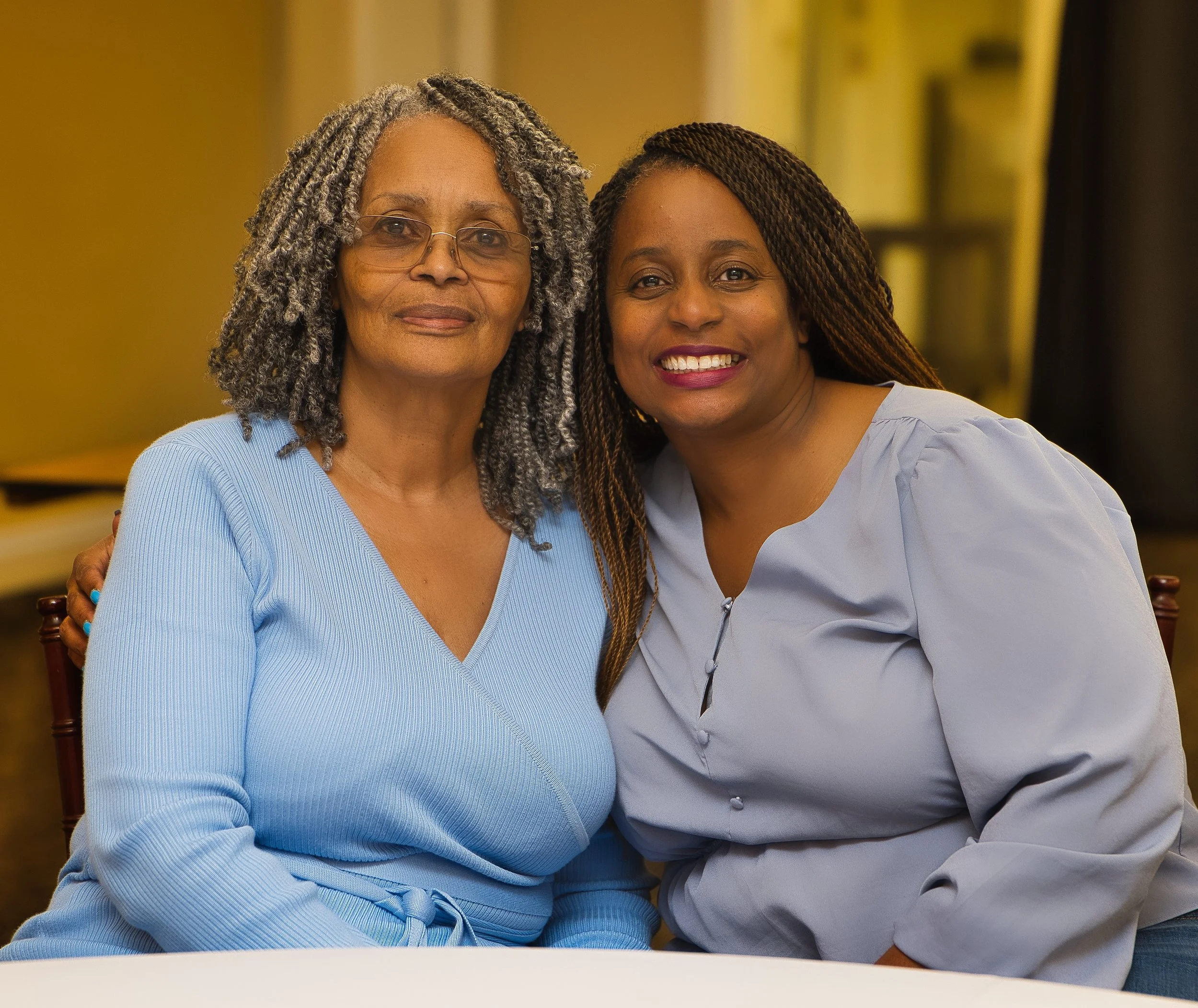 Two nice-looking black women smiling at an event