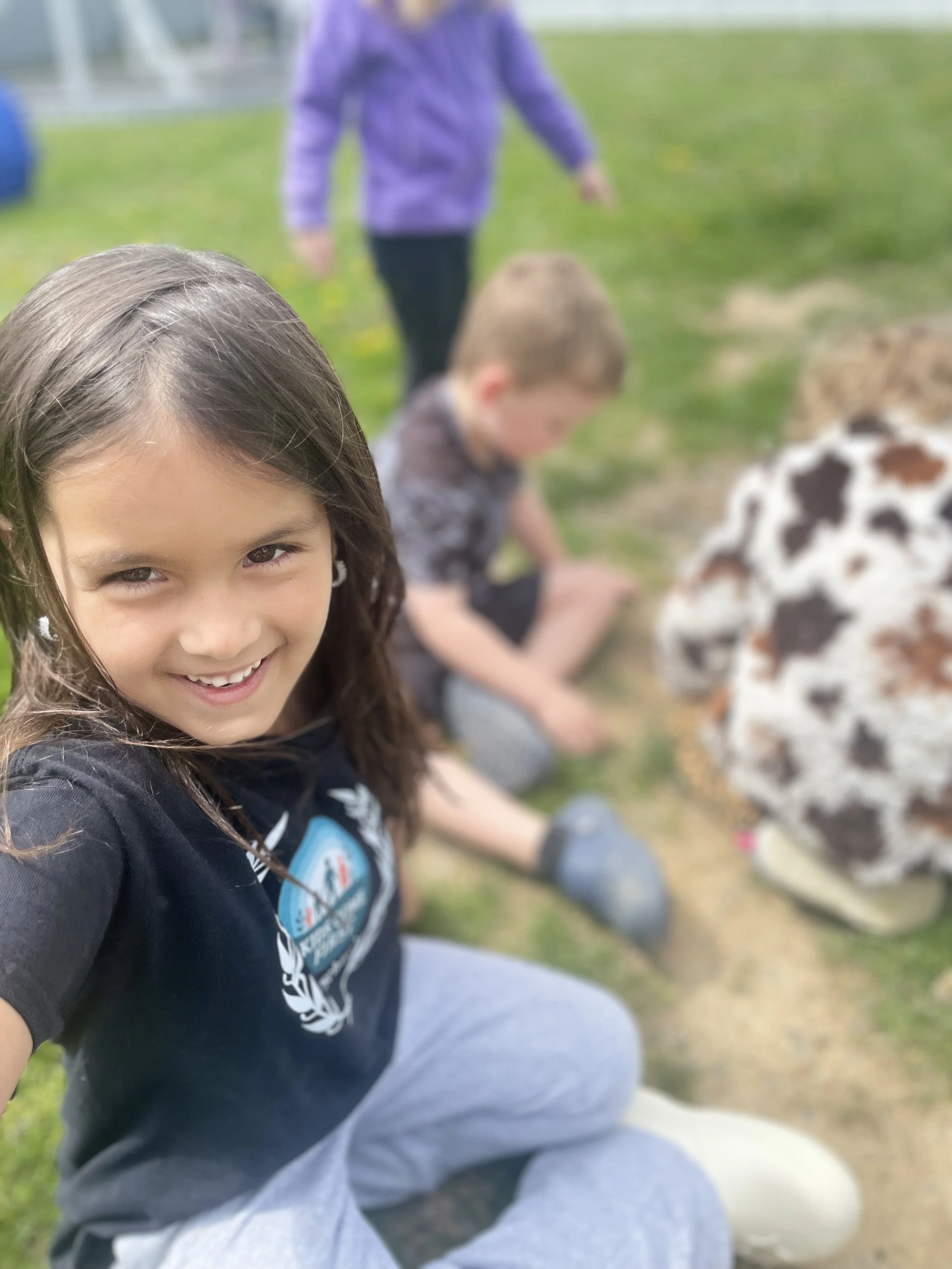 Two preschoolers toSmiling preschooler playing outside on the grass with friendsgether in the Kids Come First classroom