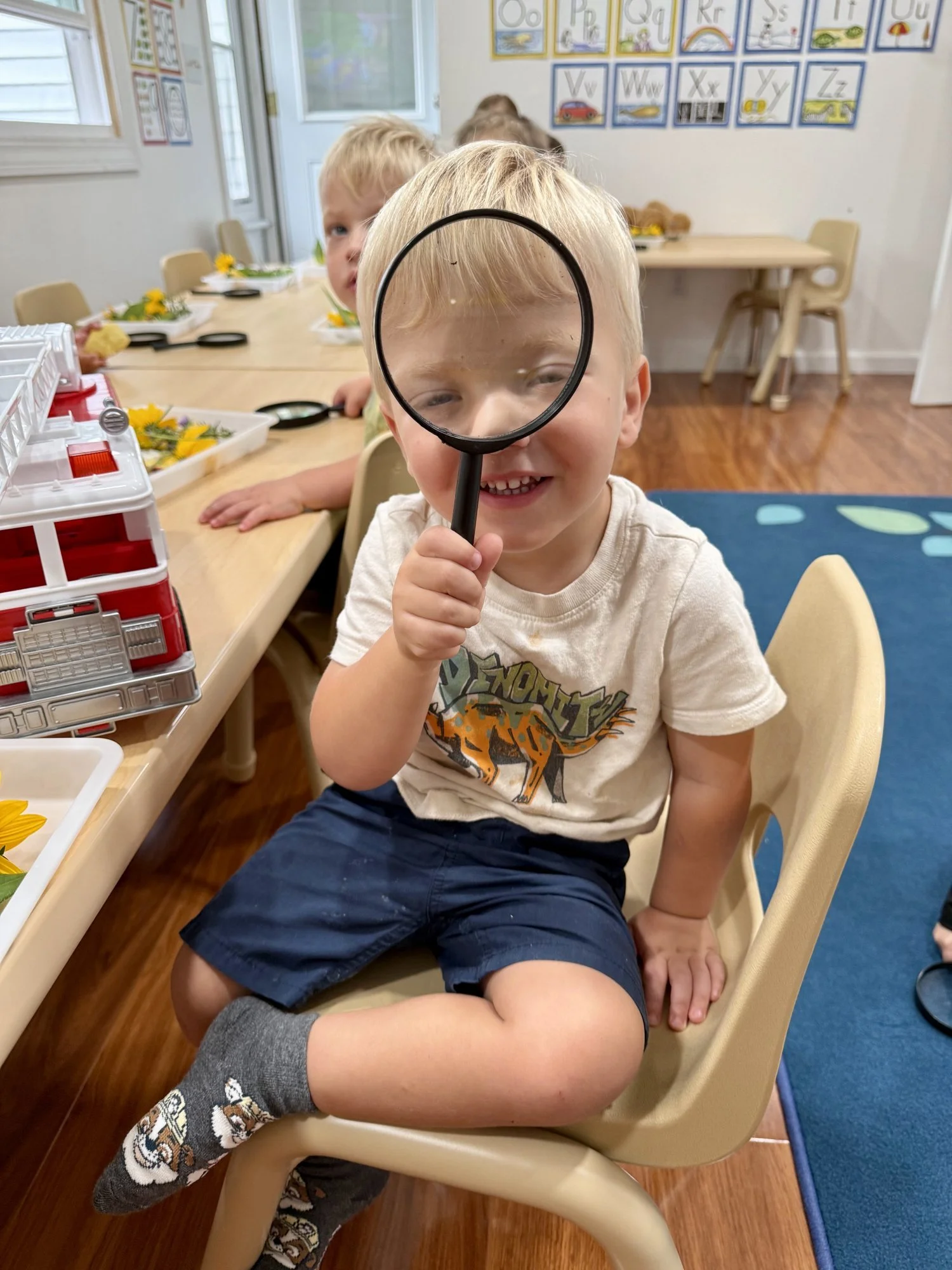 Preschooler smiling through a magnifying glass