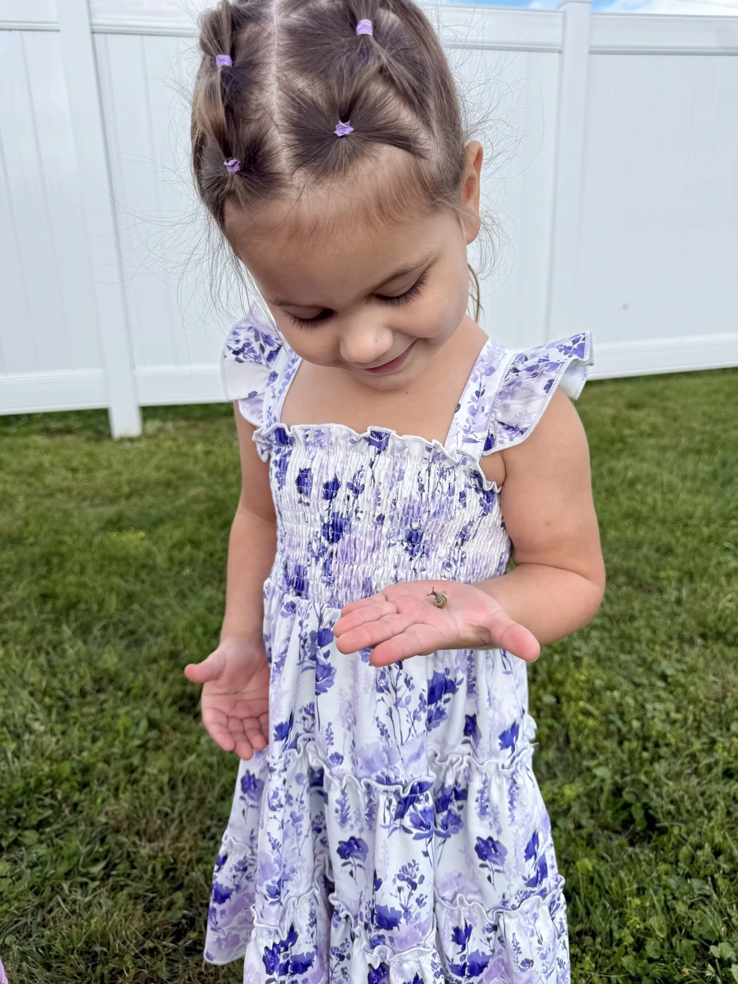 Preschooler gently holding a snail she found outside