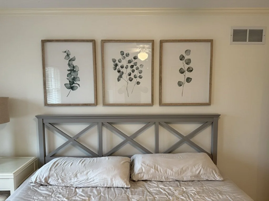 Finished bedroom installation featuring wall-mounted framed artwork above a headboard, completed as part of a residential handyman home improvement project.