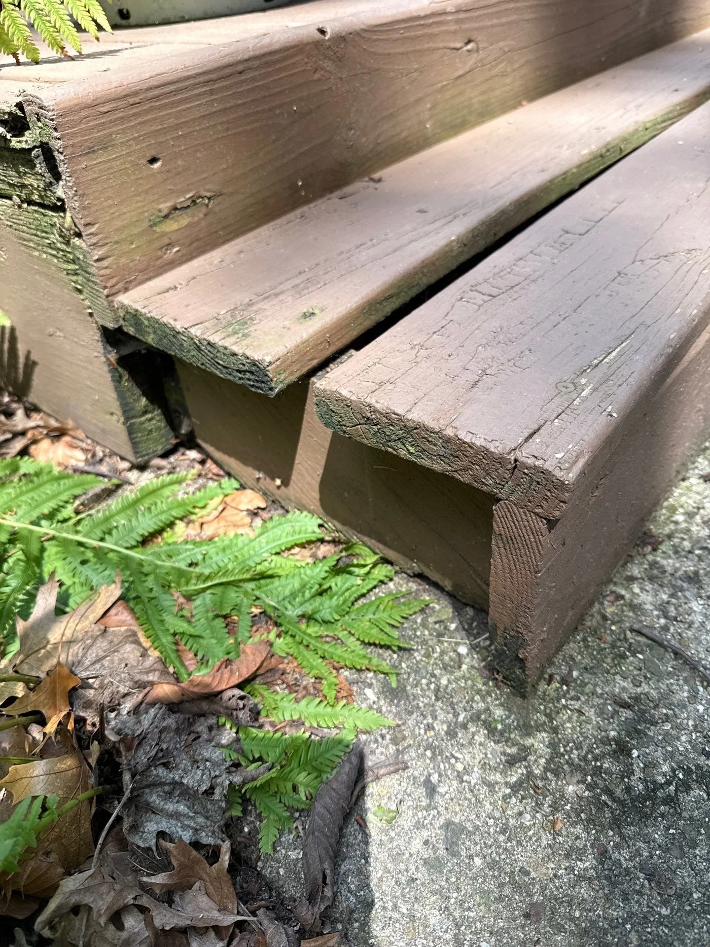 Cracked and weathered wooden deck stairs showing signs of splitting and moisture damage at a home in South Bend, Indiana, highlighting common deck repair issues caused by seasonal weather exposure.