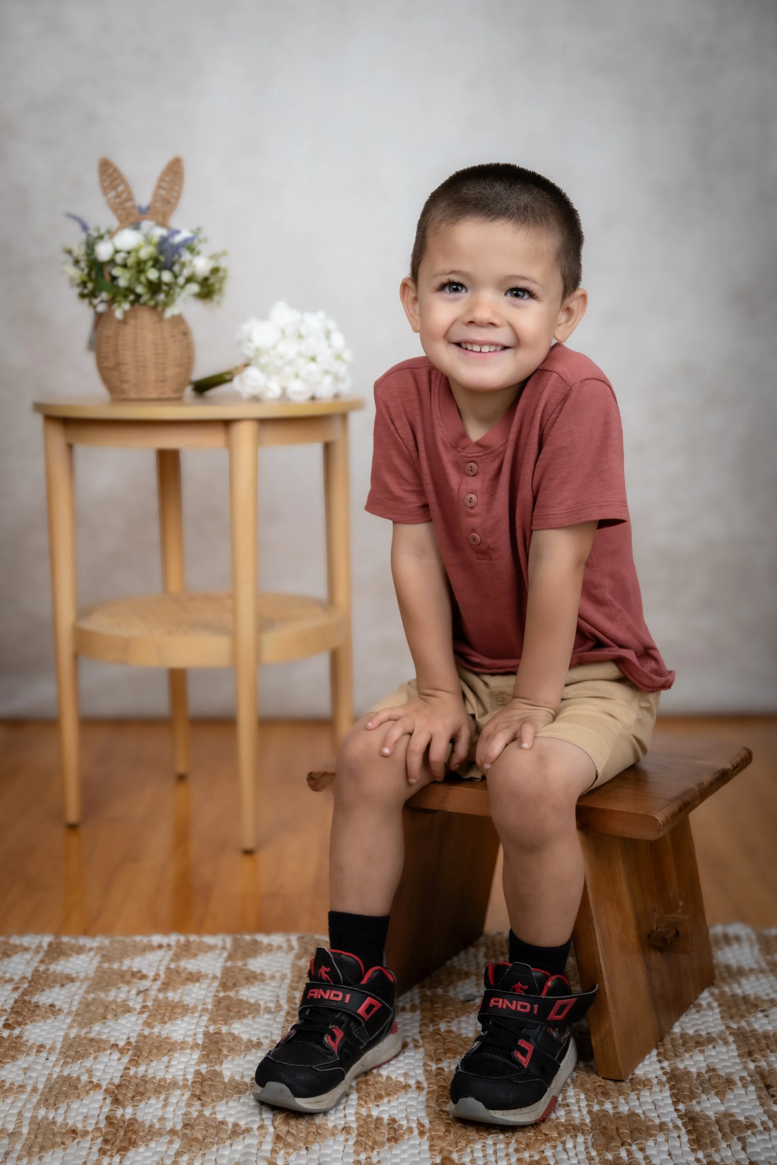 Young student seated beside a wooden stool during a preschool photography session in Newbury Park