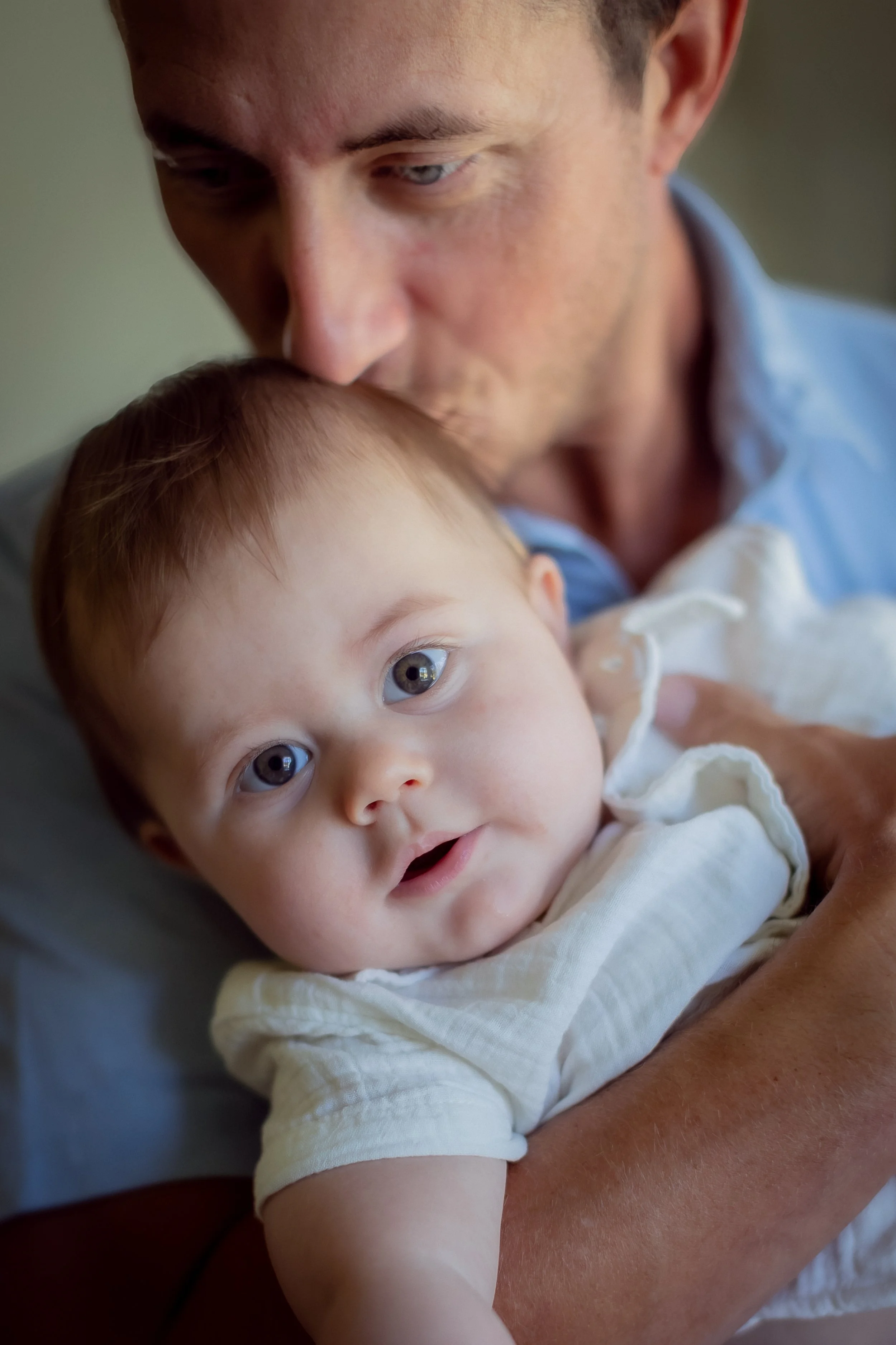 Father kissing his baby's head during an in-home family session in Westlake Village