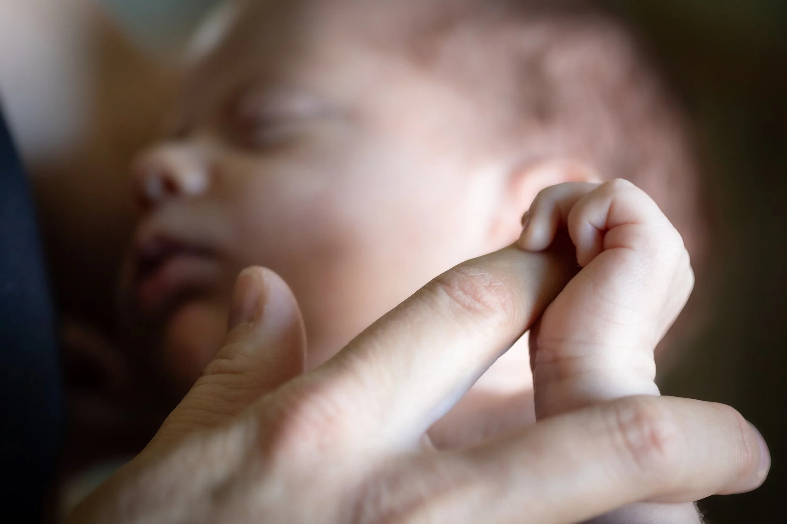 Newborn holding a parent's finger during an in-home newborn session in Thousand Oaks