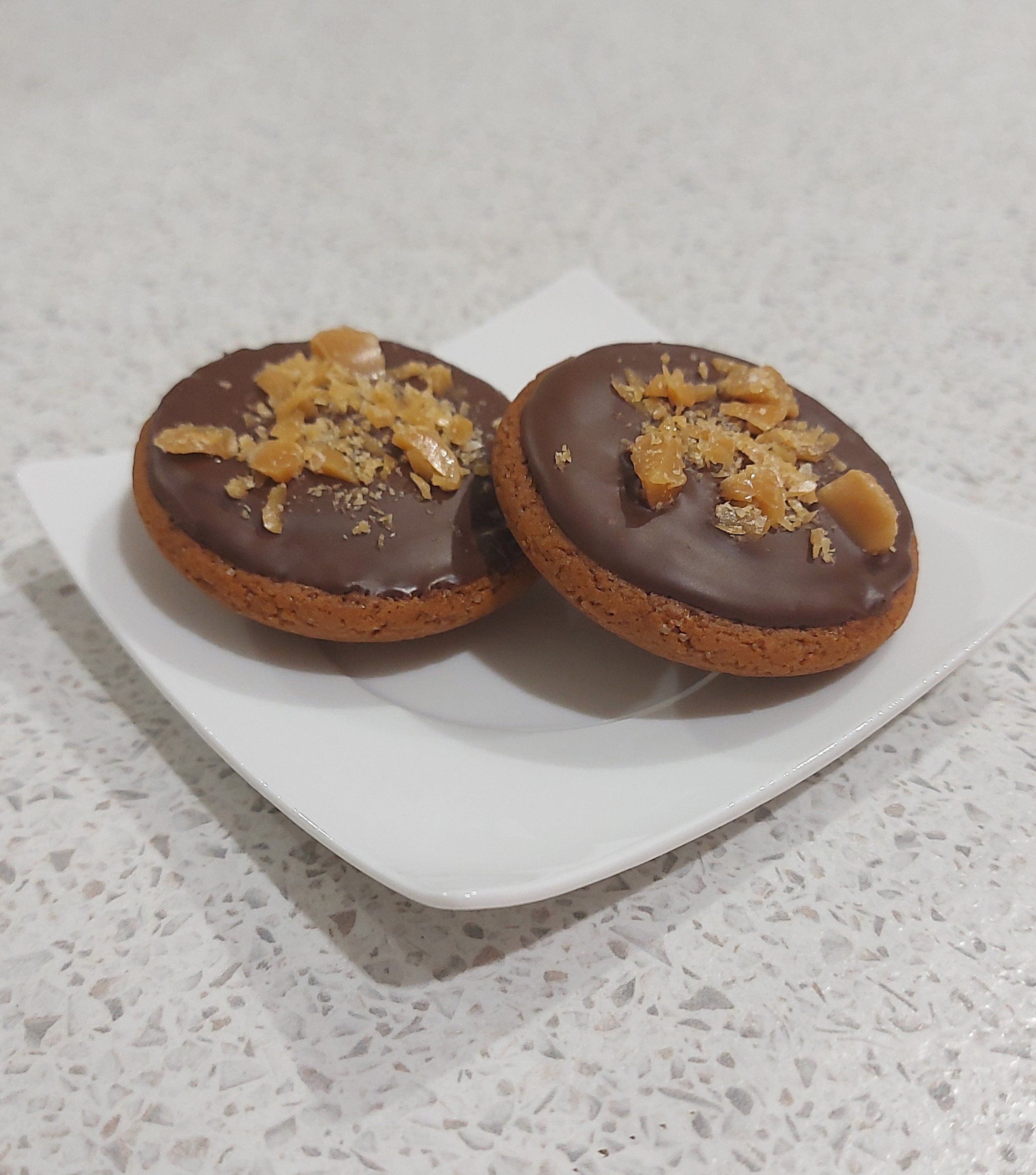 Caramle tarts with a ginger base, topped with cholocalte and toffee shards