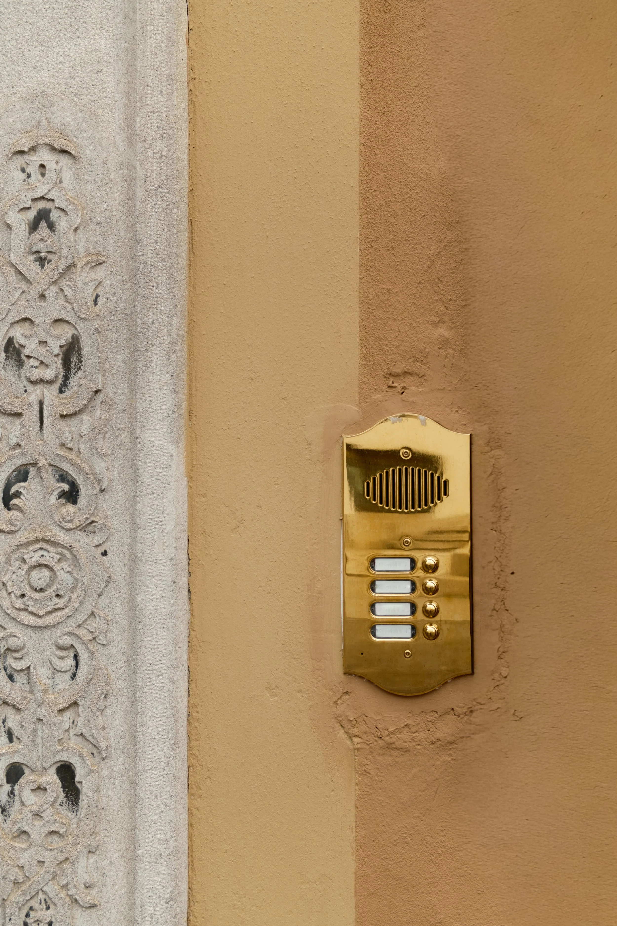 kaboompics_gold-brass-doorbell-panel-next-to-ornate-stone-column-italy-42871.jpg