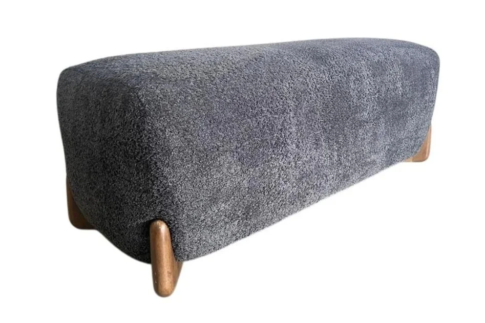 A modern, gray fabric upholstered bench with wooden legs.