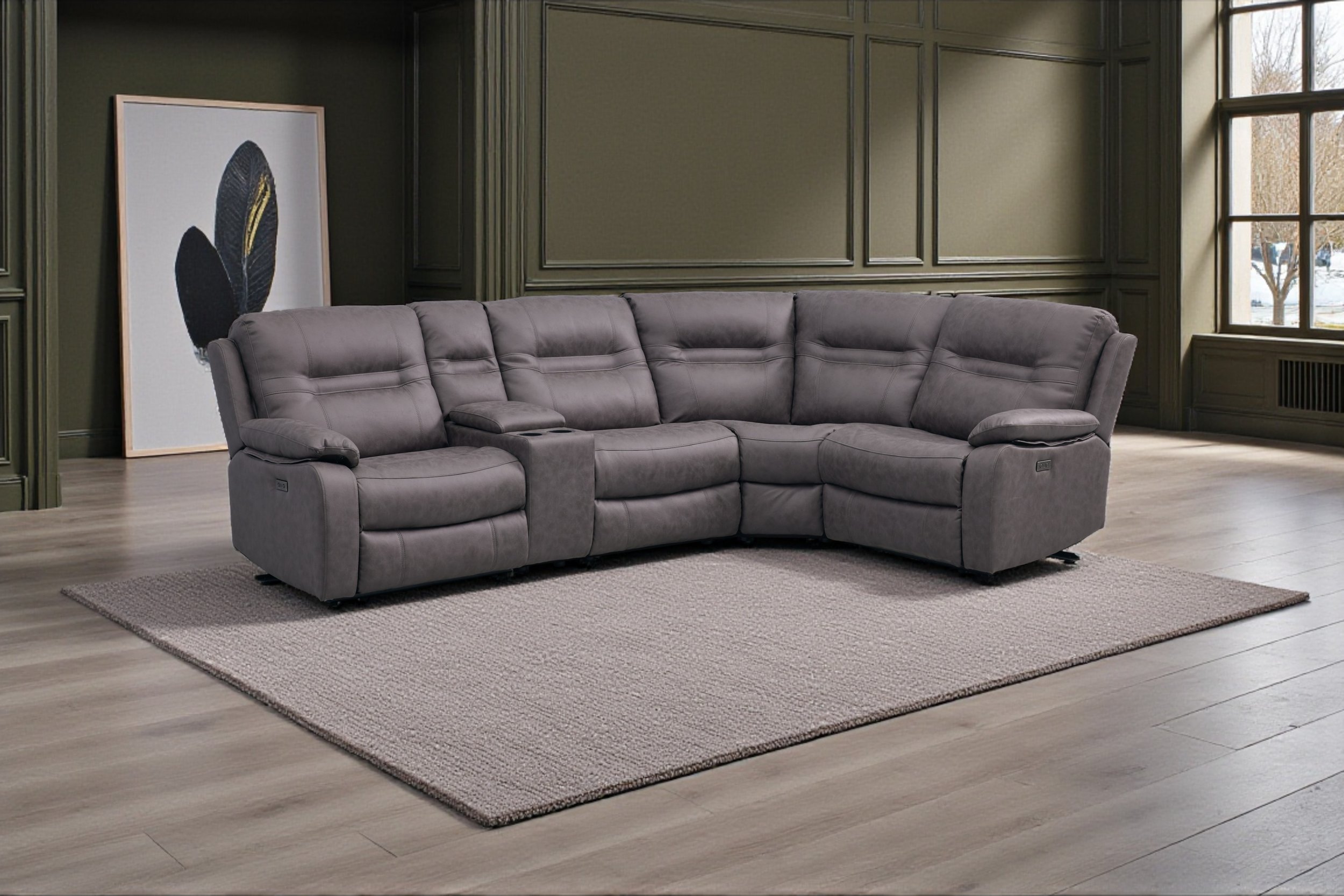 Gray sectional sofa in a living room with white walls, a beige curtain, and a large window, with a small side table and a framed abstract art piece.