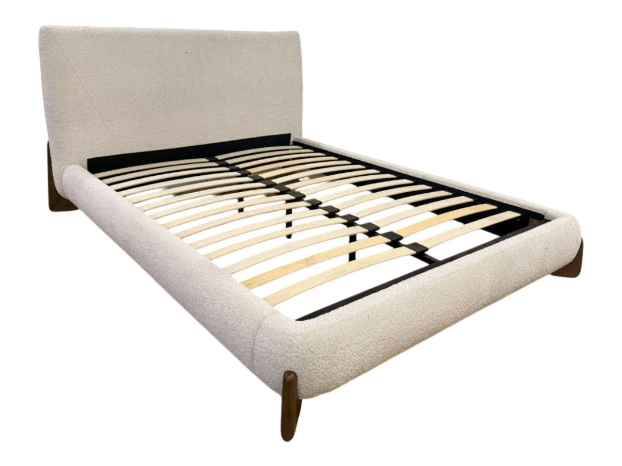 A bed frame with a beige upholstery, wooden legs, and a black metal slatted support system inside.
