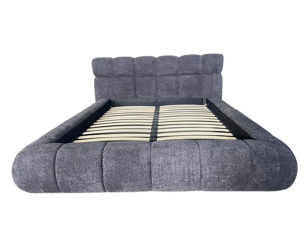 Grey upholstered bed frame with a headboard, no mattress, and wooden slats visible