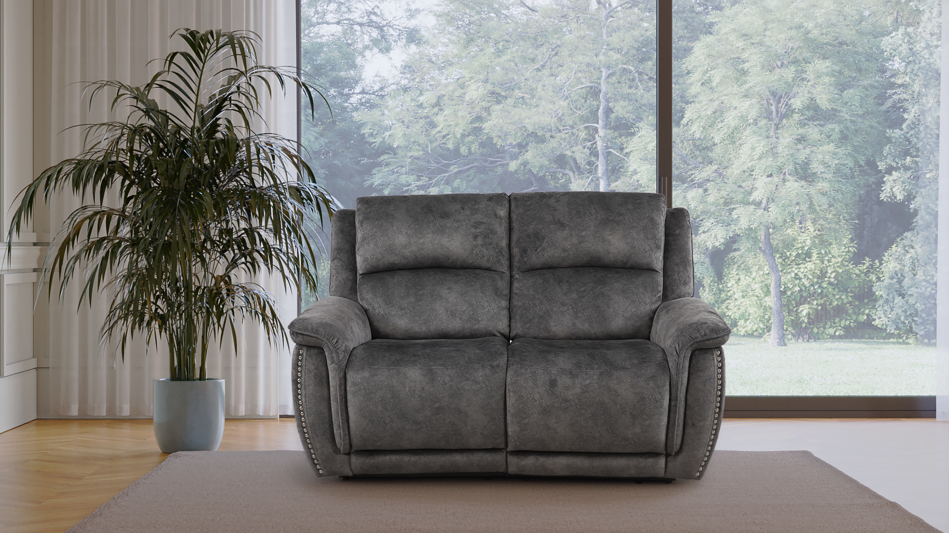 Living room with a gray sofa and a green potted plant next to large window showing trees outside.