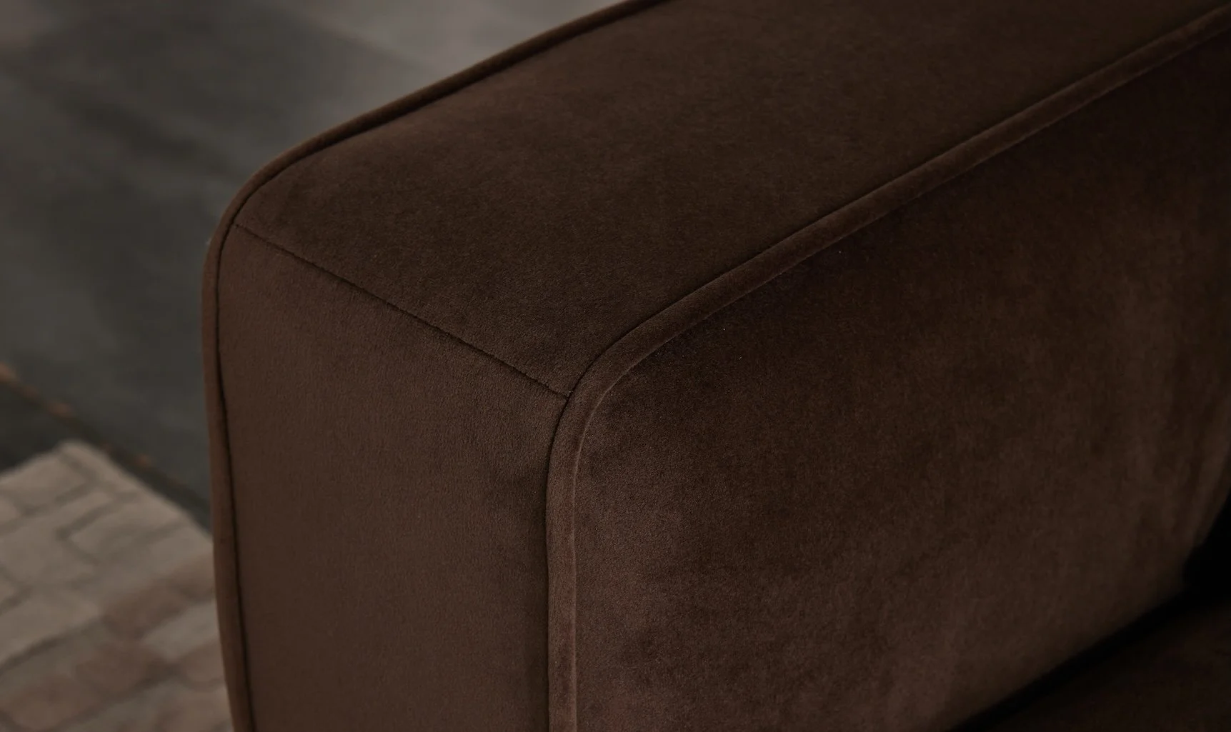 Close-up of a brown upholstered armrest of a sofa or chair.